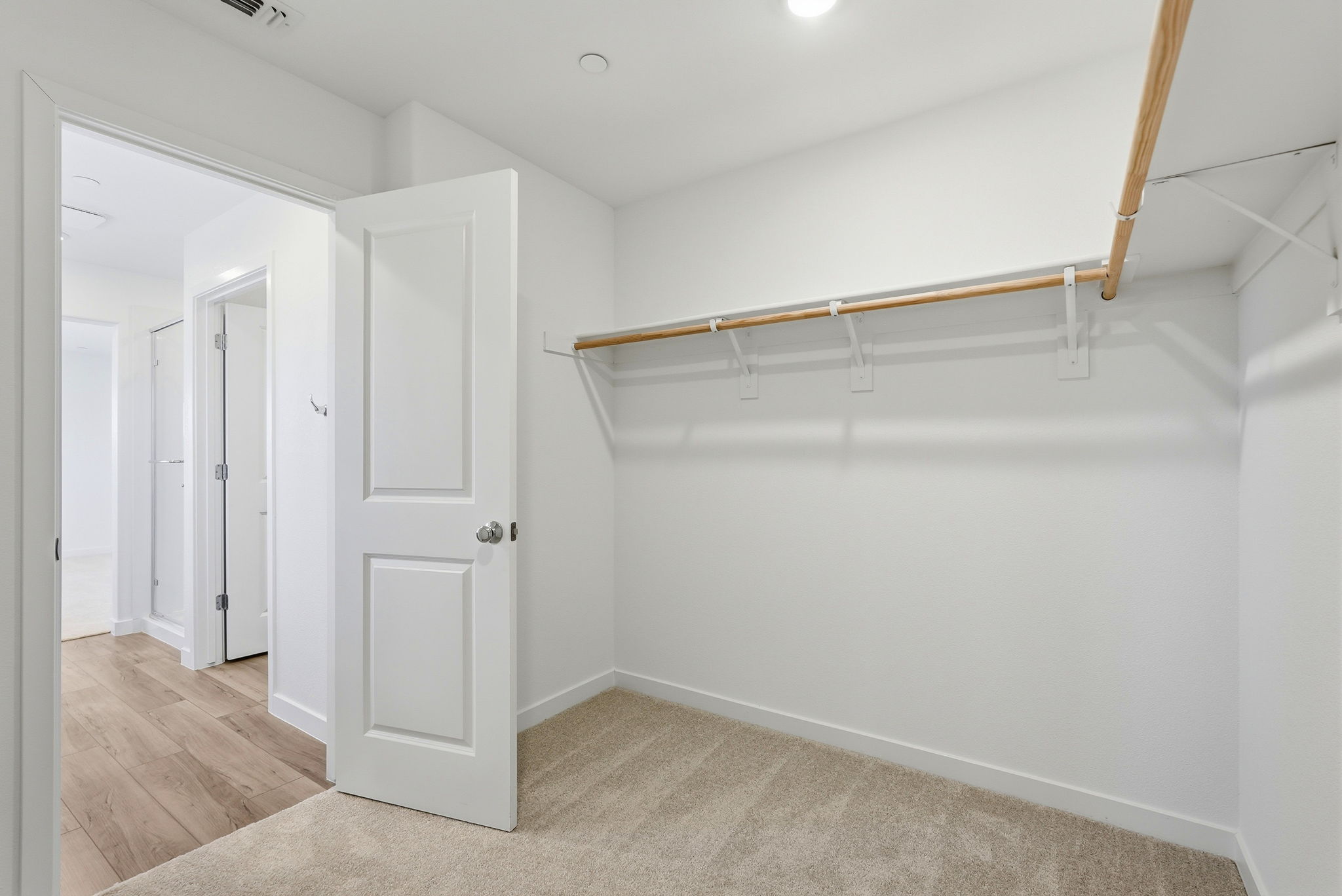 A room with white walls and a wood railing.