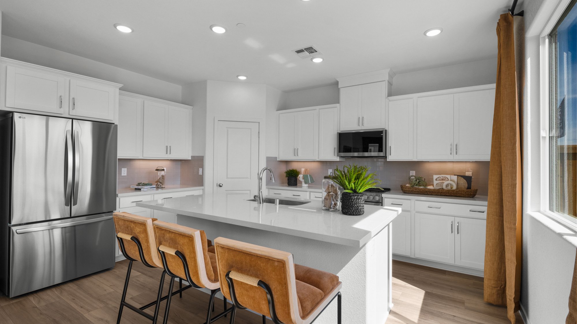 A kitchen with white cabinets.