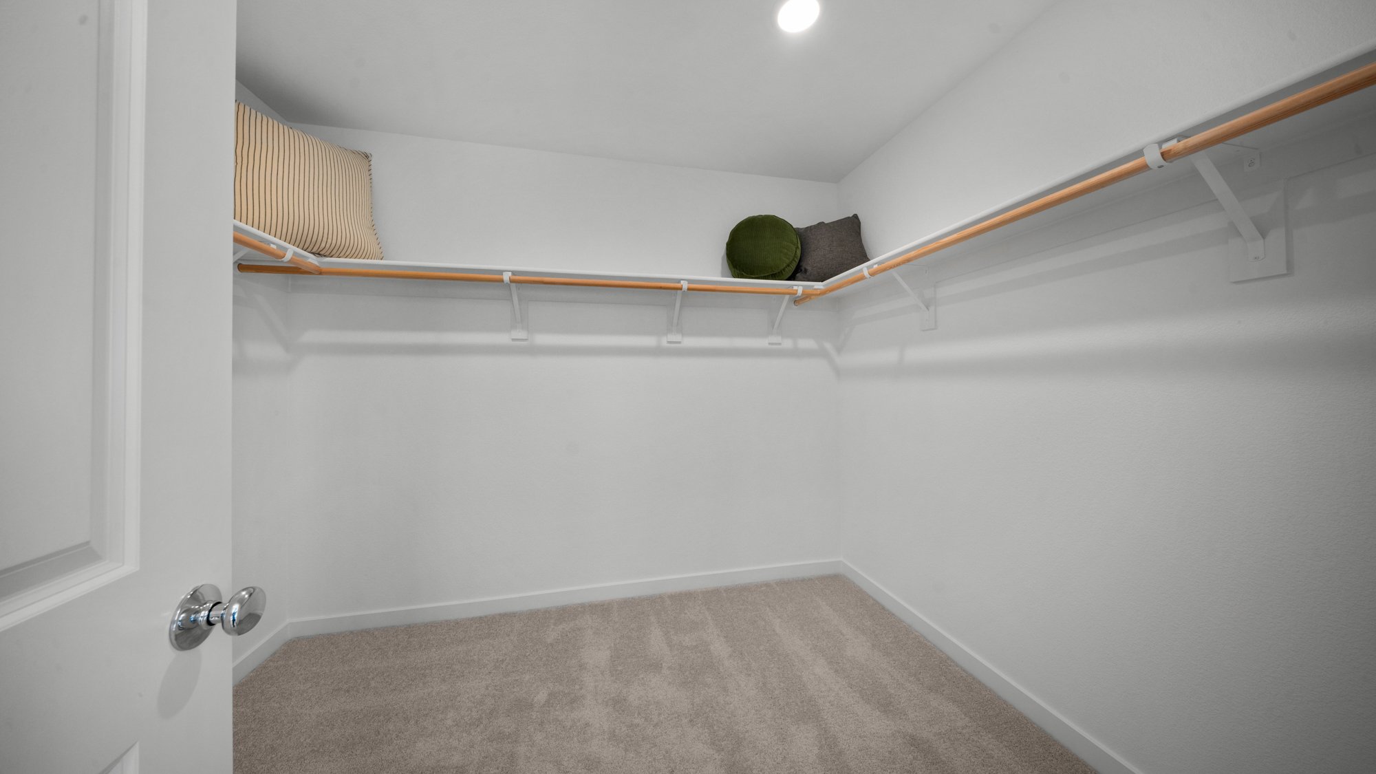 A white room with a white wall and a brown rug.