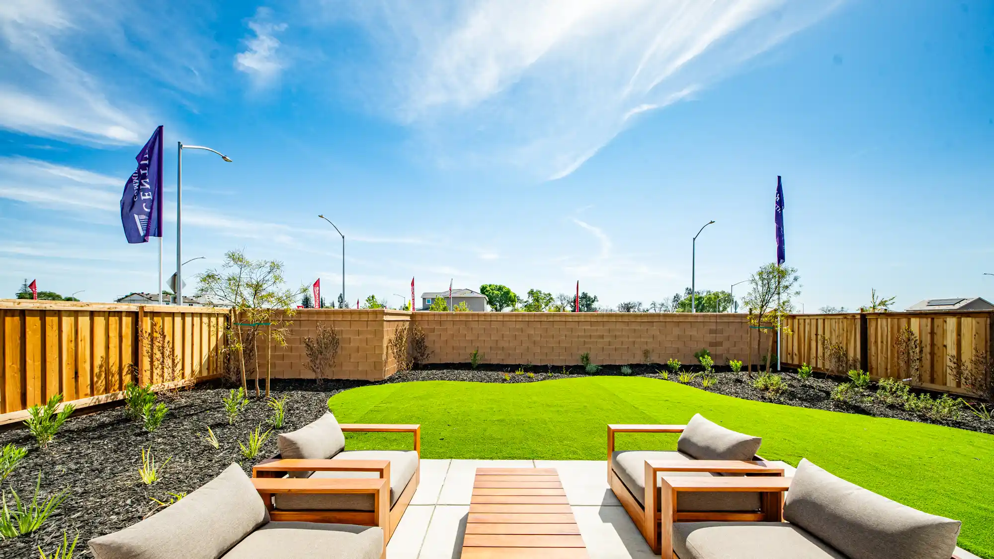 A patio with chairs and a fence.