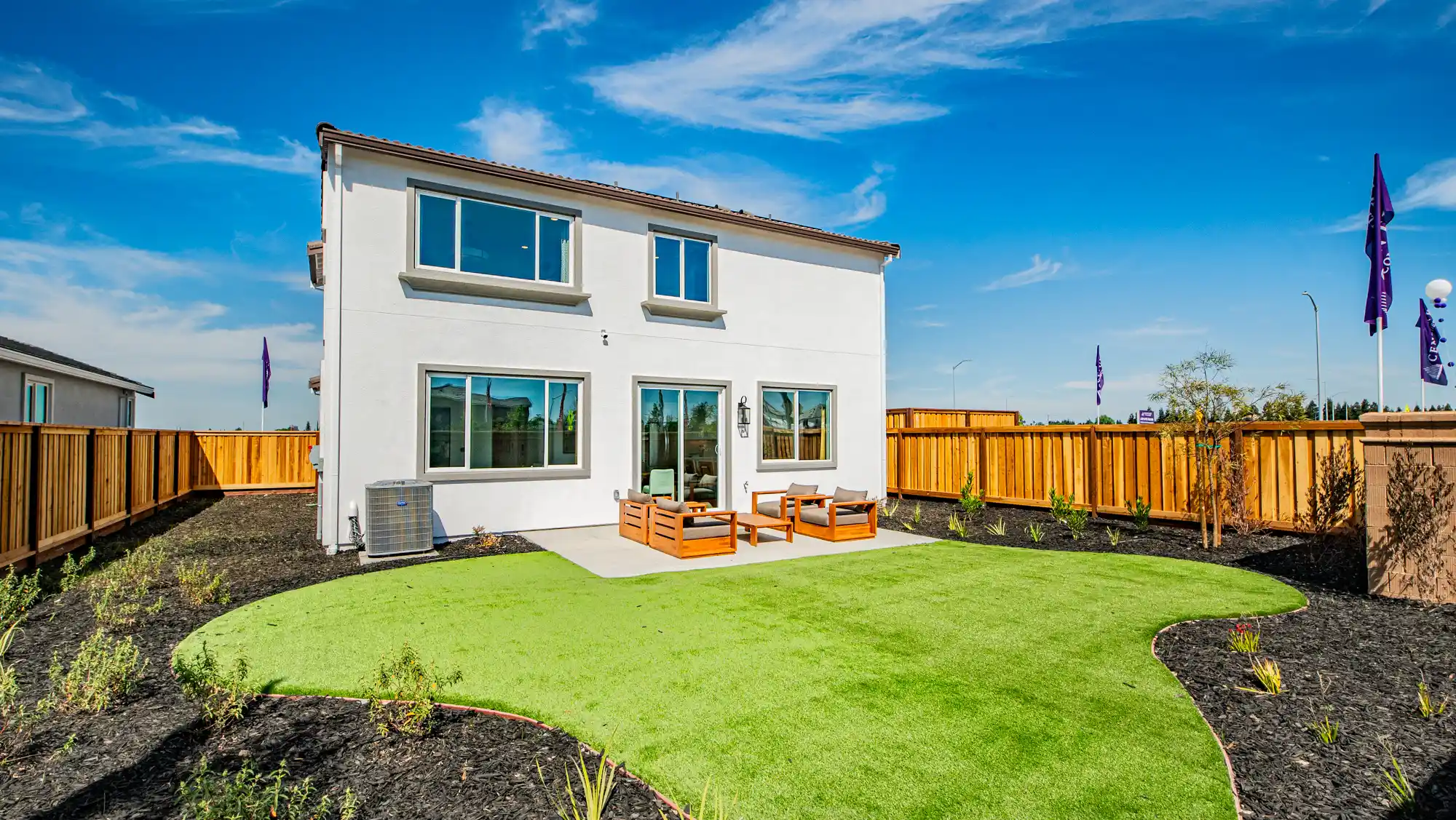 A house with a fence and a yard with a wood fence.