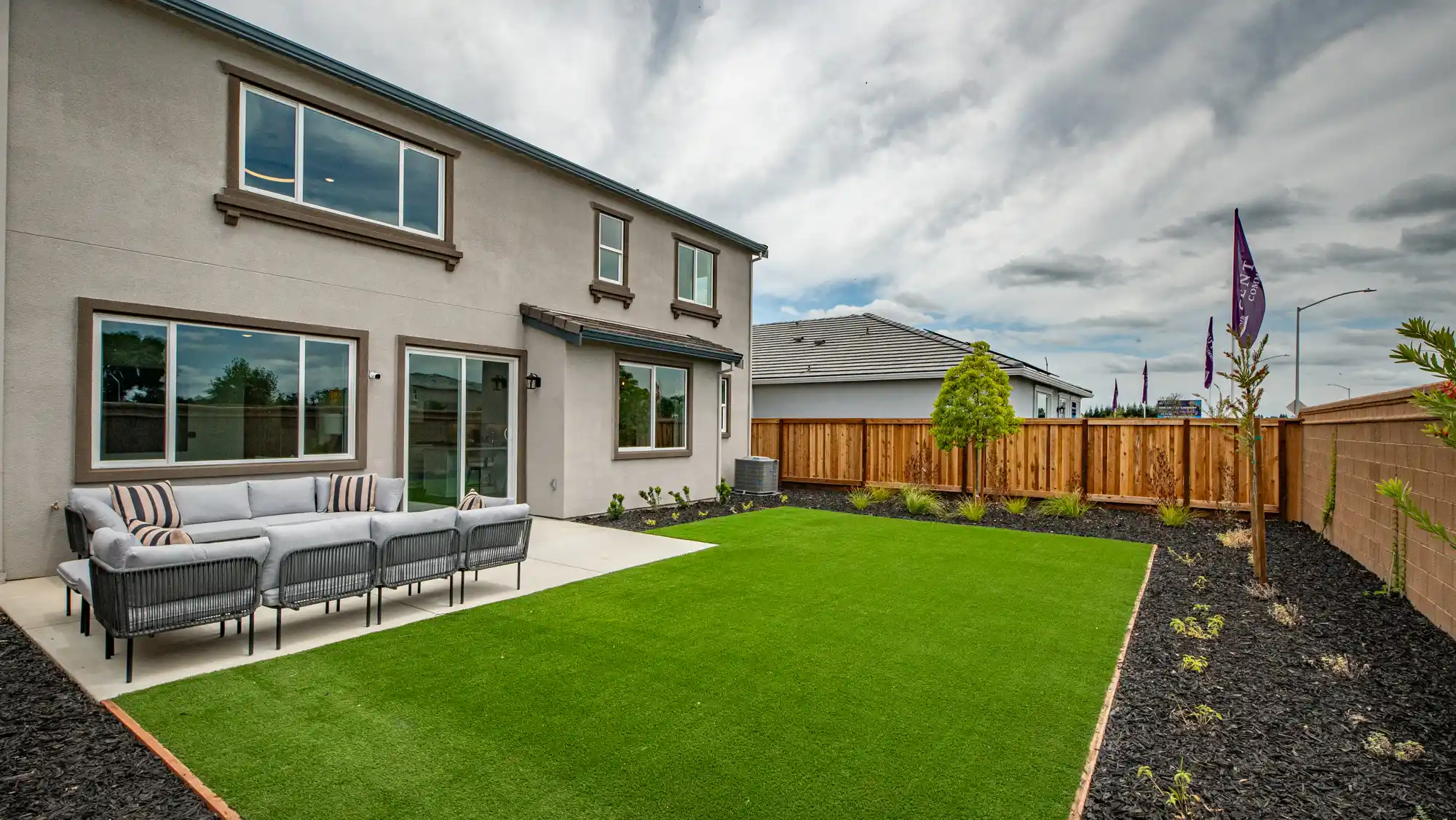 A backyard with a fence and a house.