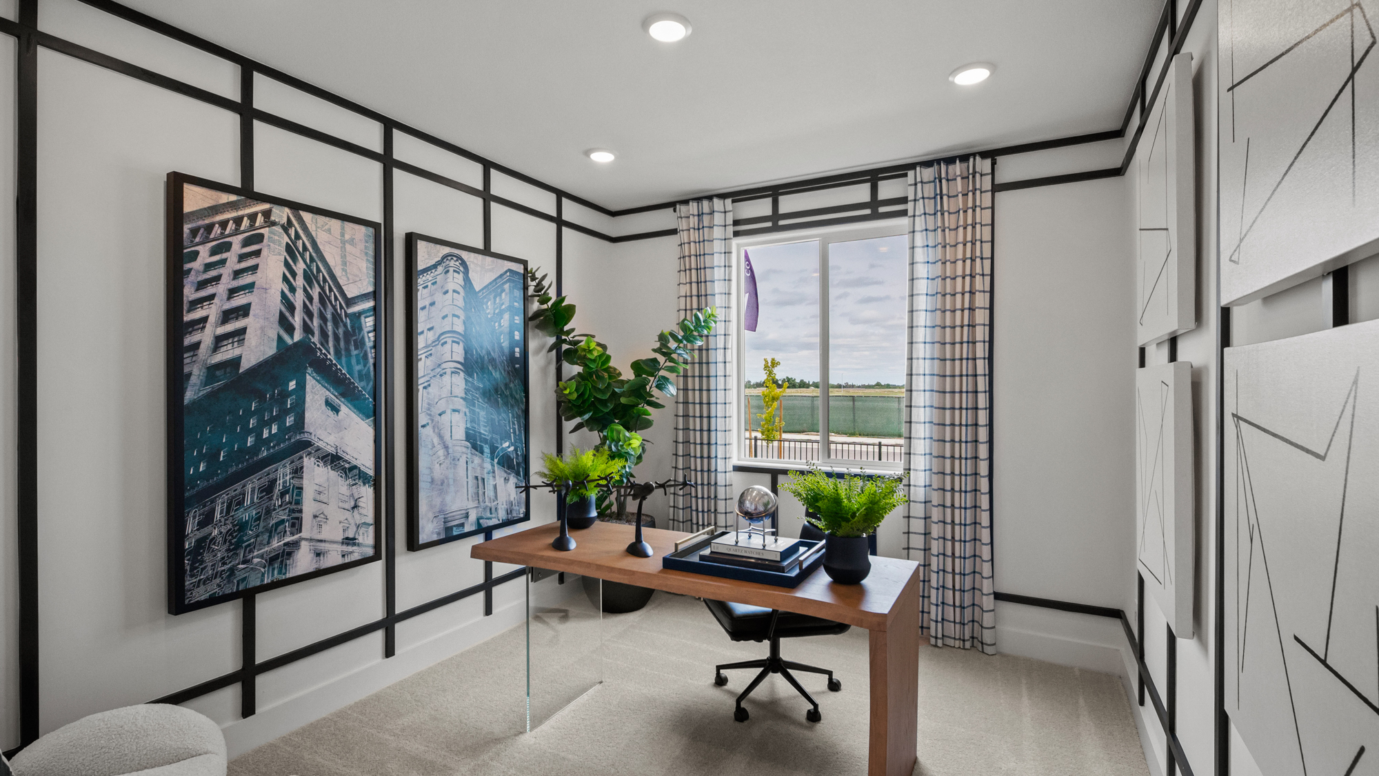 A room with a desk and plants.