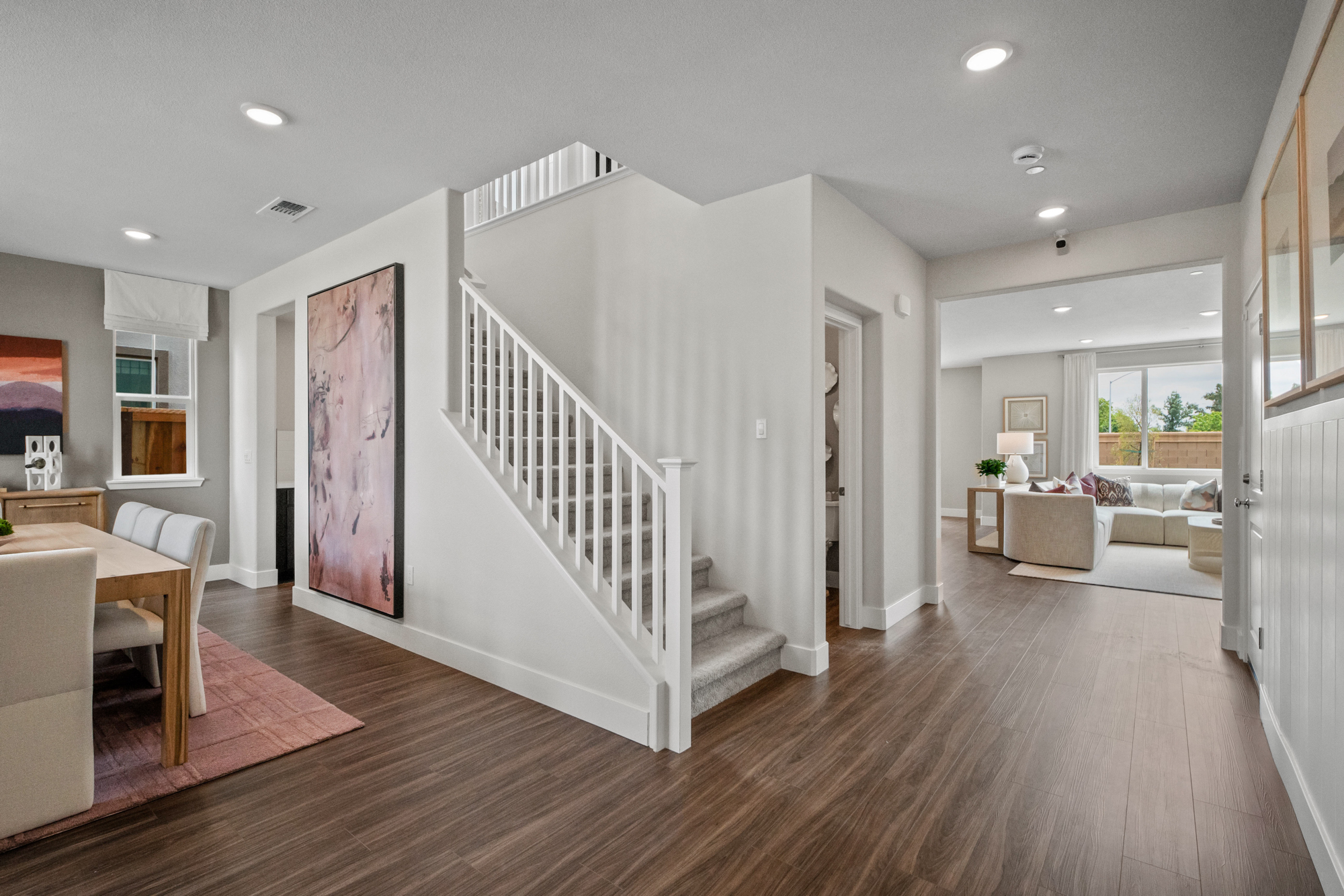 A large living room with a wood floor and white walls.