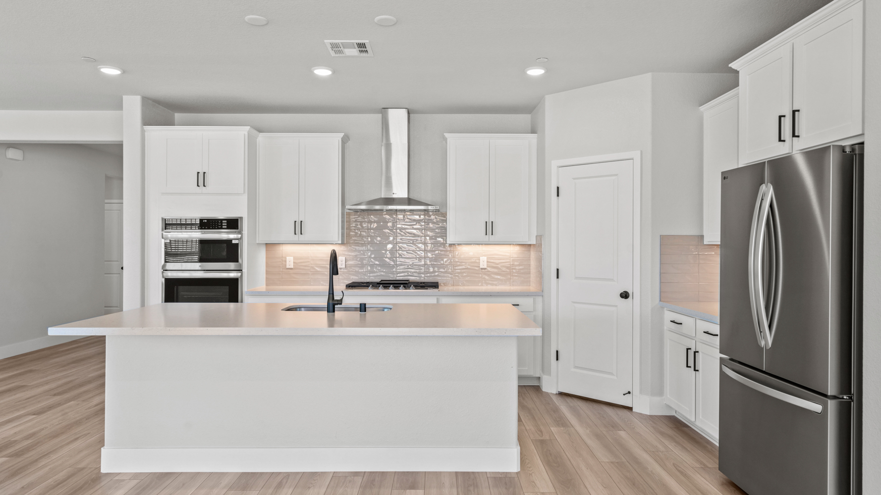 A kitchen with white cabinets.