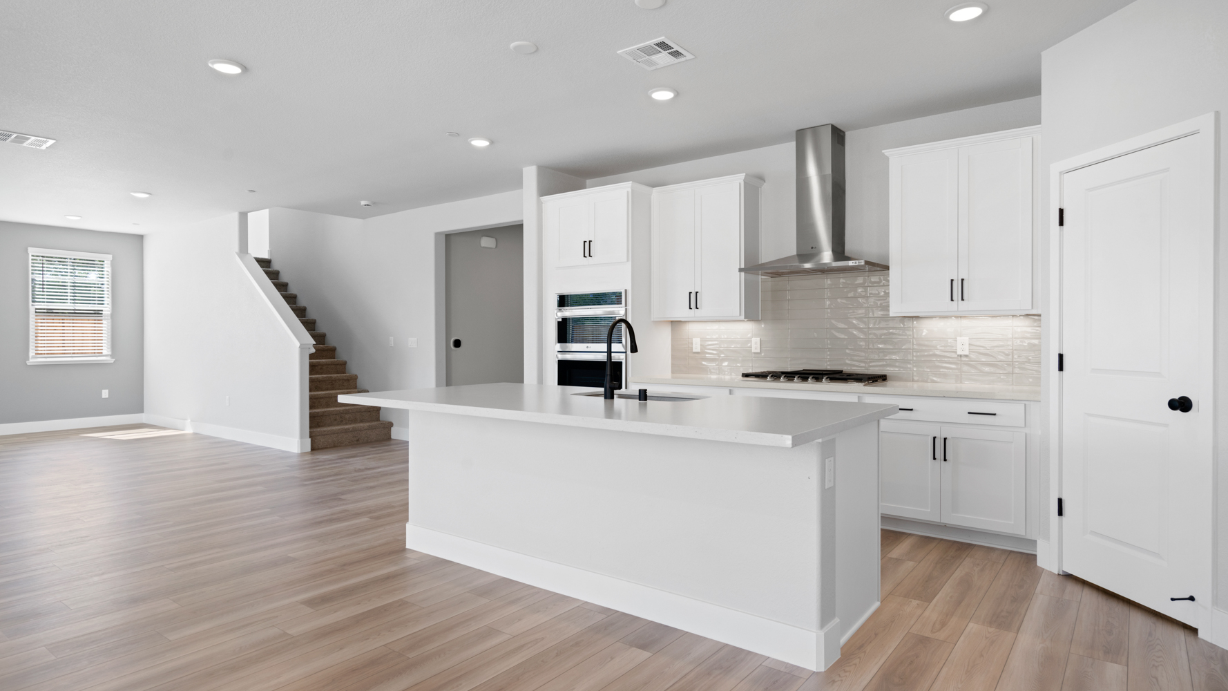 A kitchen with white cabinets.