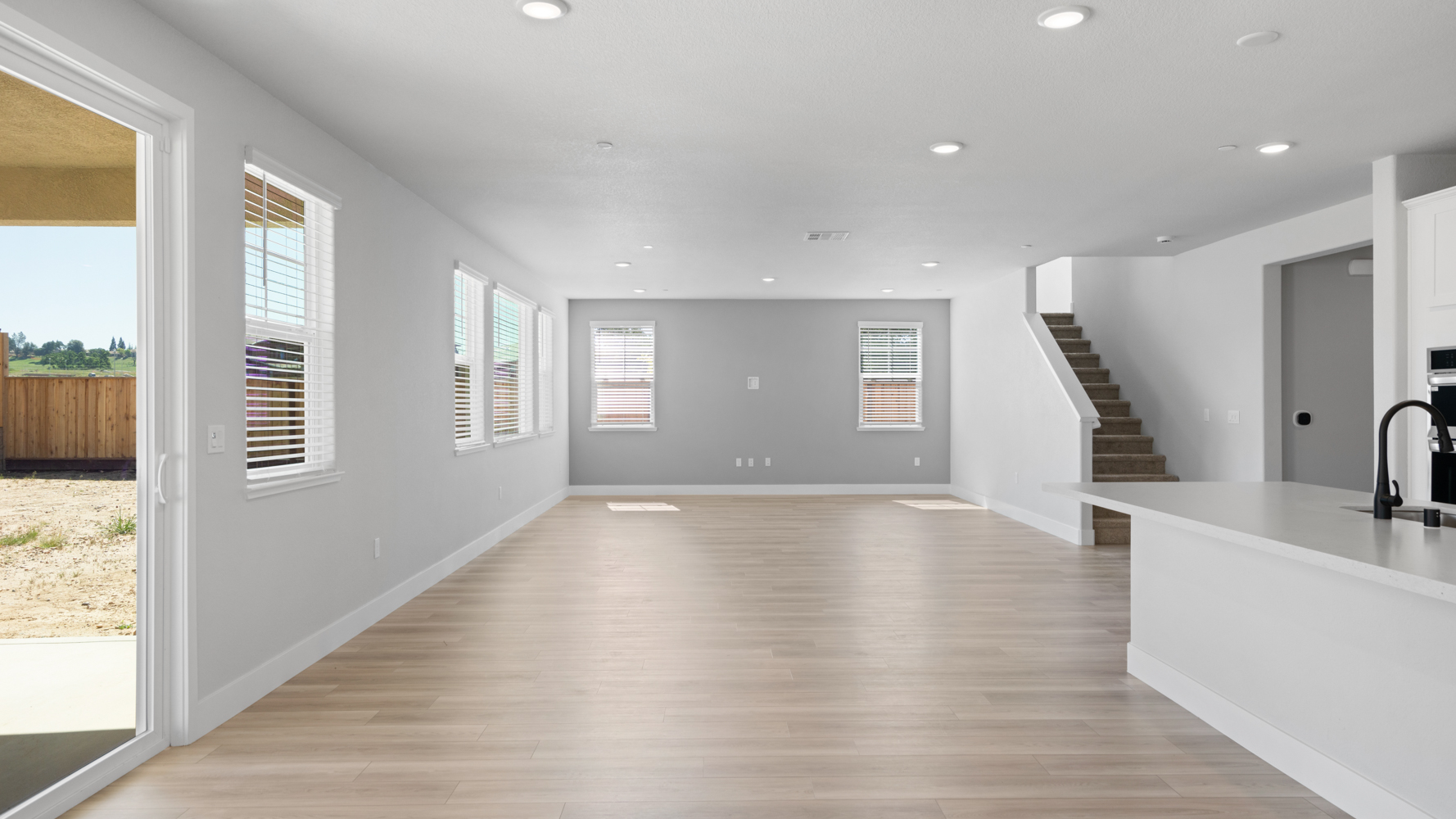 A large empty room with a wood floor and a wood floor.