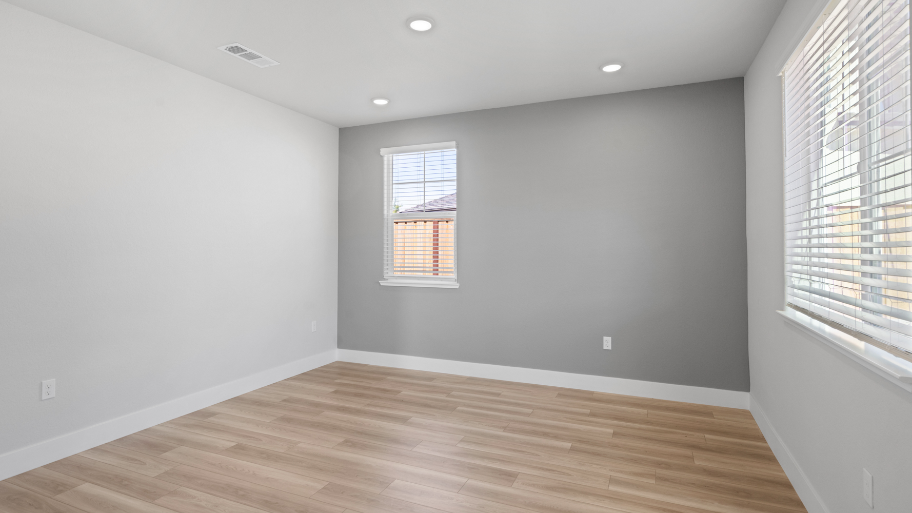 A room with a wood floor and windows.