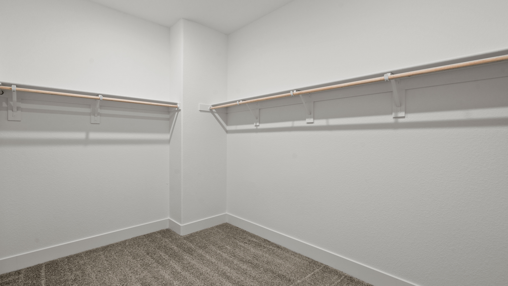 A white wall with a metal bar.