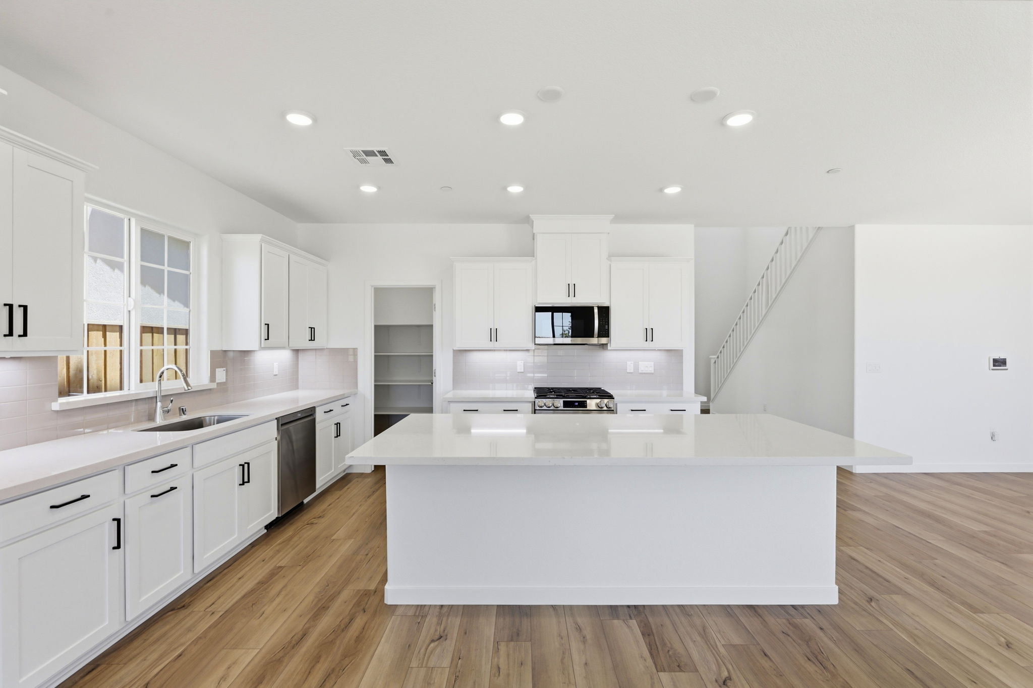 A kitchen with white cabinets.