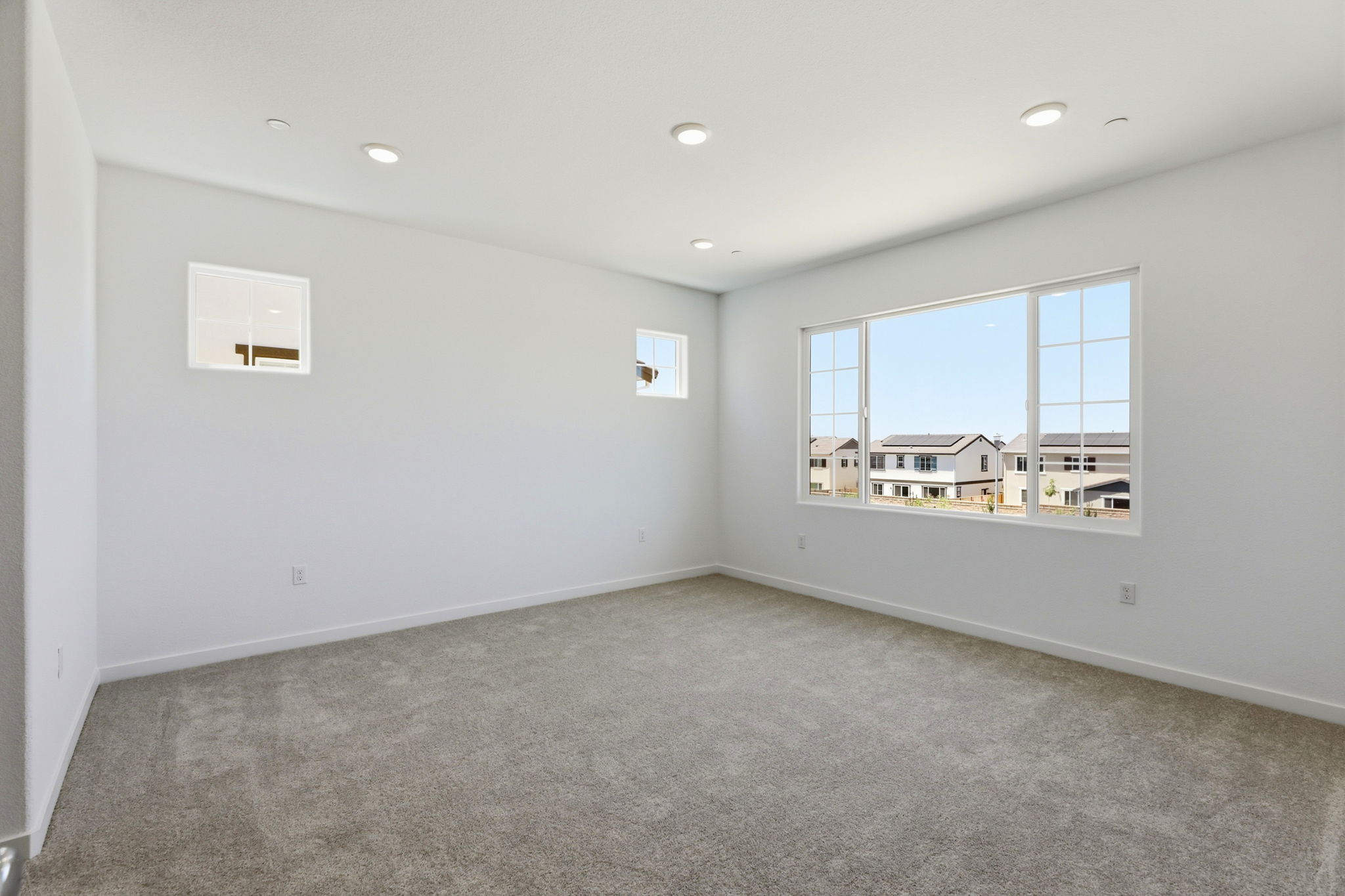 A room with a window and a wall with a view of a city.