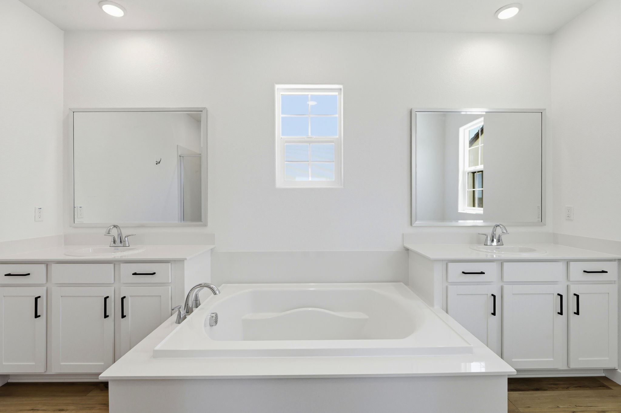 A bathroom with white cabinets.