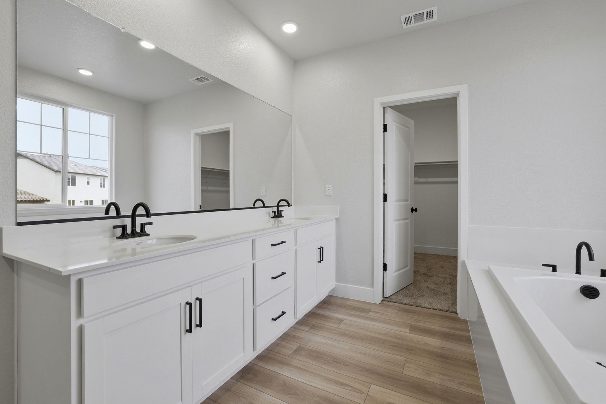 A bathroom with white cabinets.