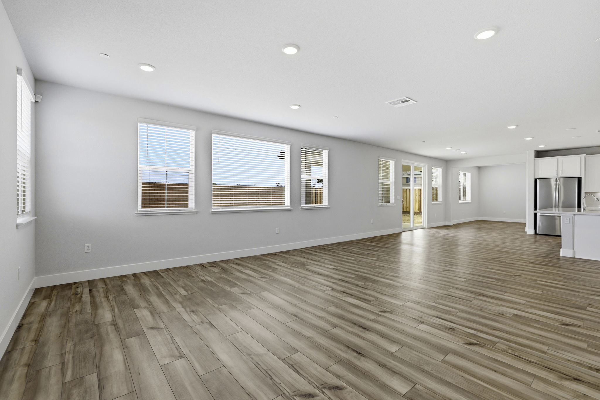 A large empty room with a wood floor and white walls.
