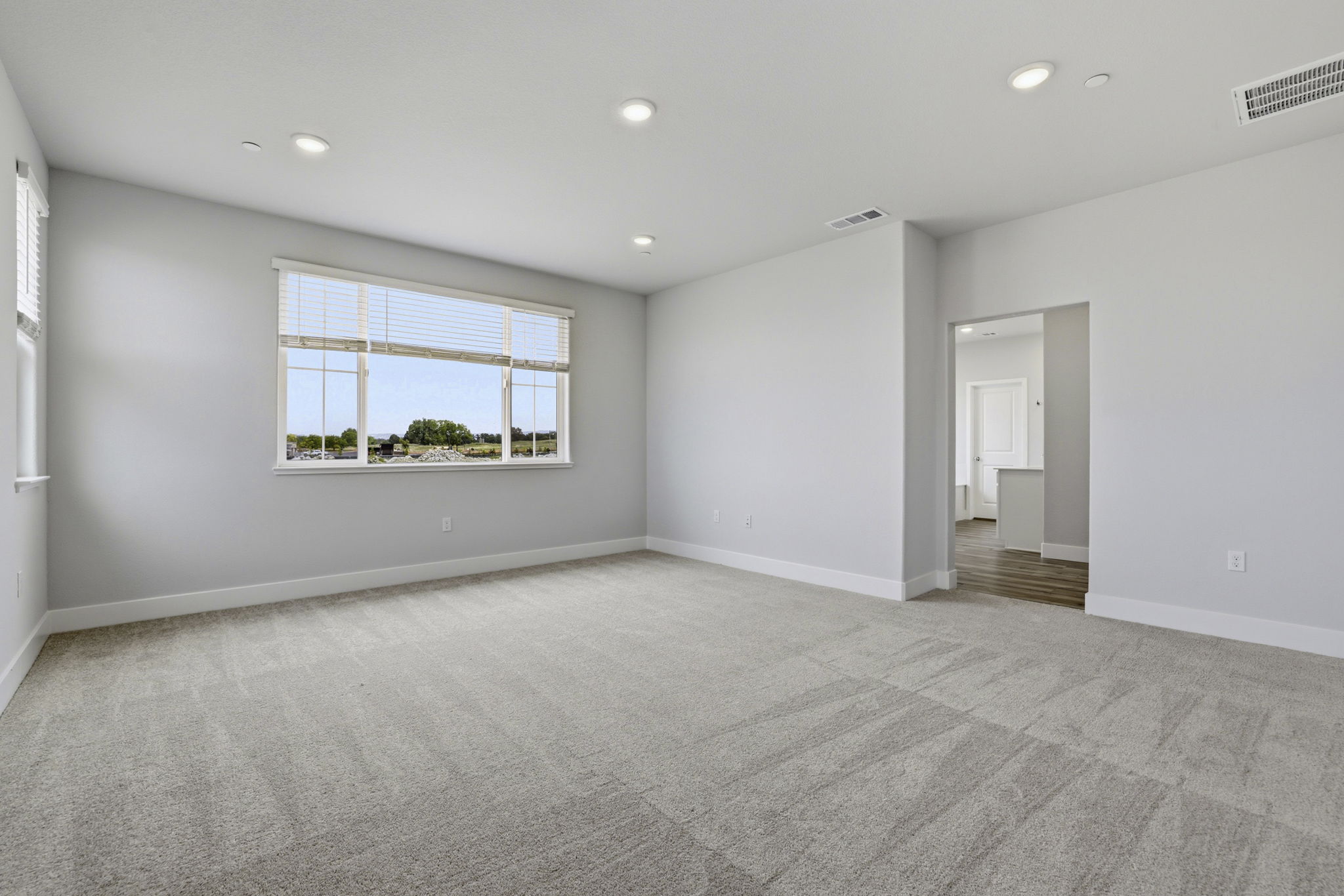 A room with a carpet and a window.