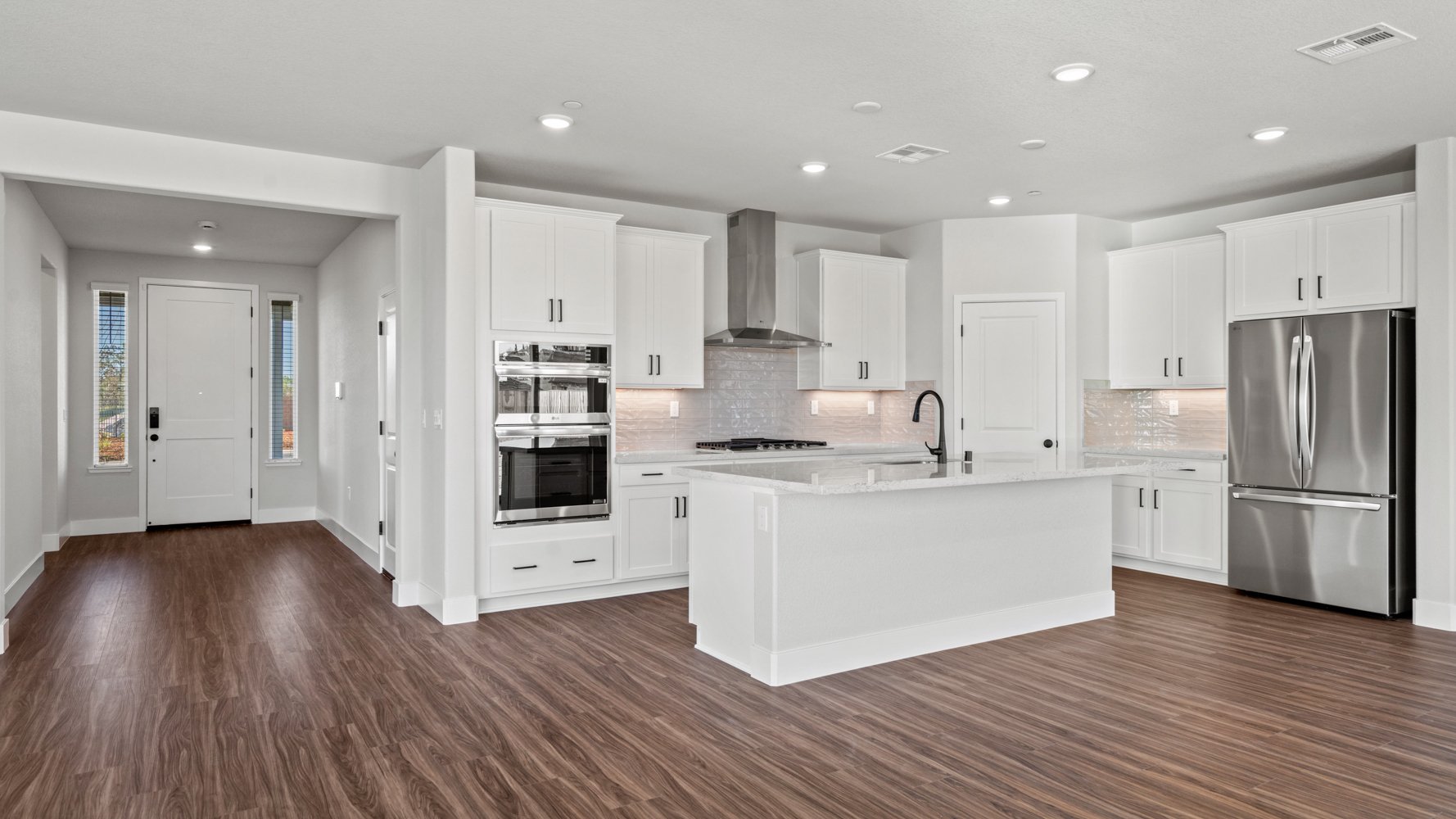 A kitchen with white cabinets.