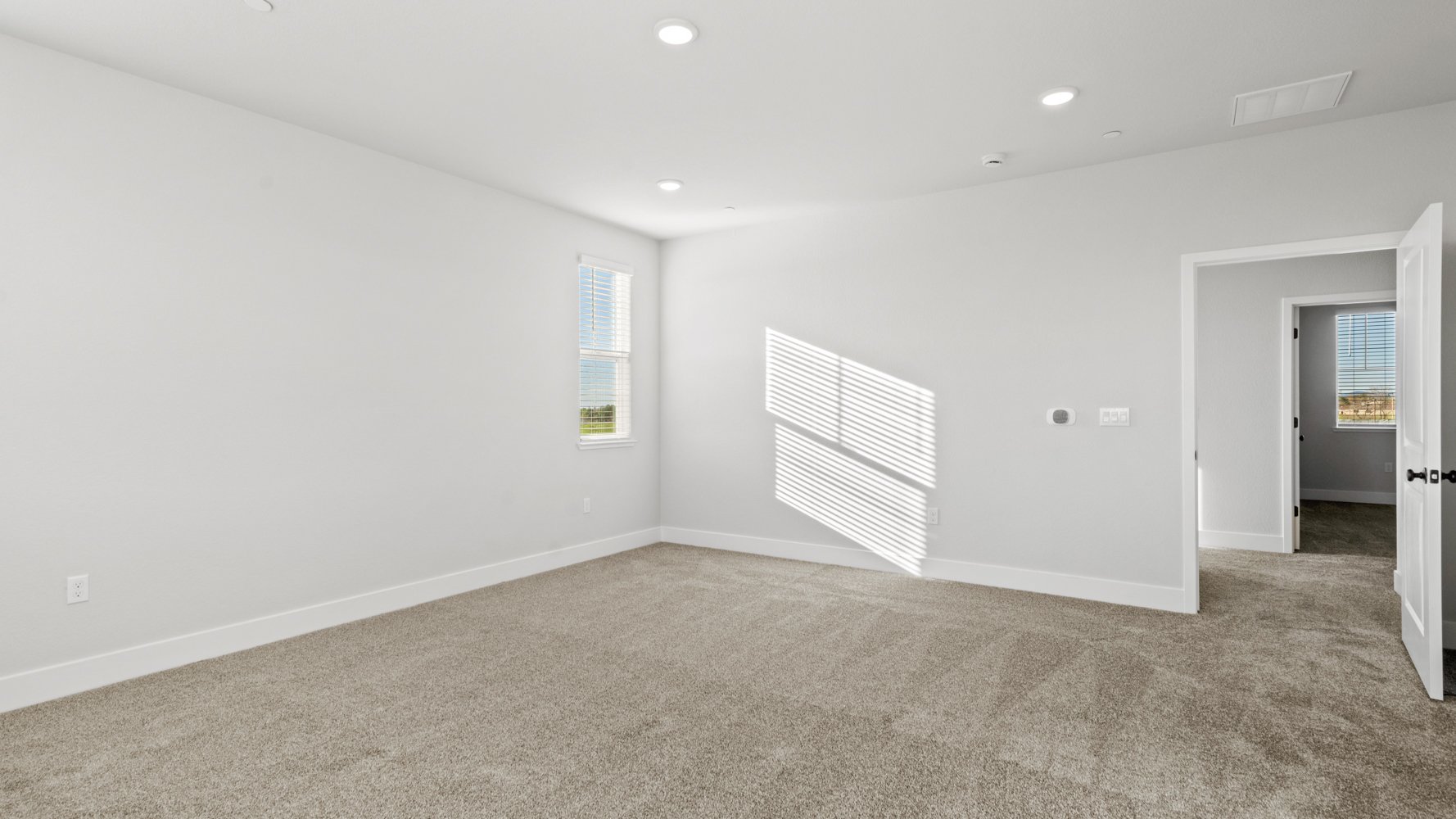 A room with a carpet and a door.