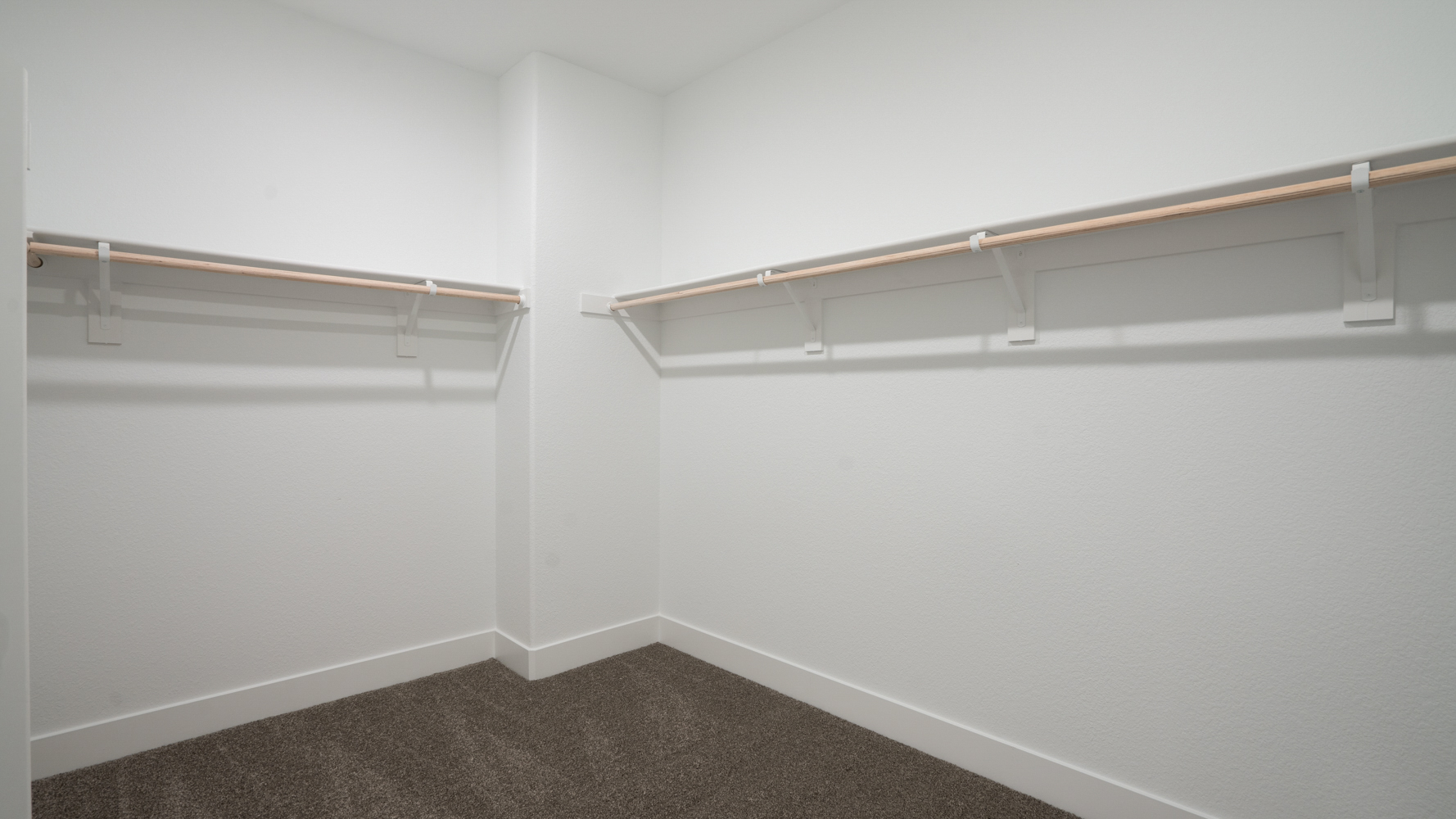 A white wall with a metal bar.