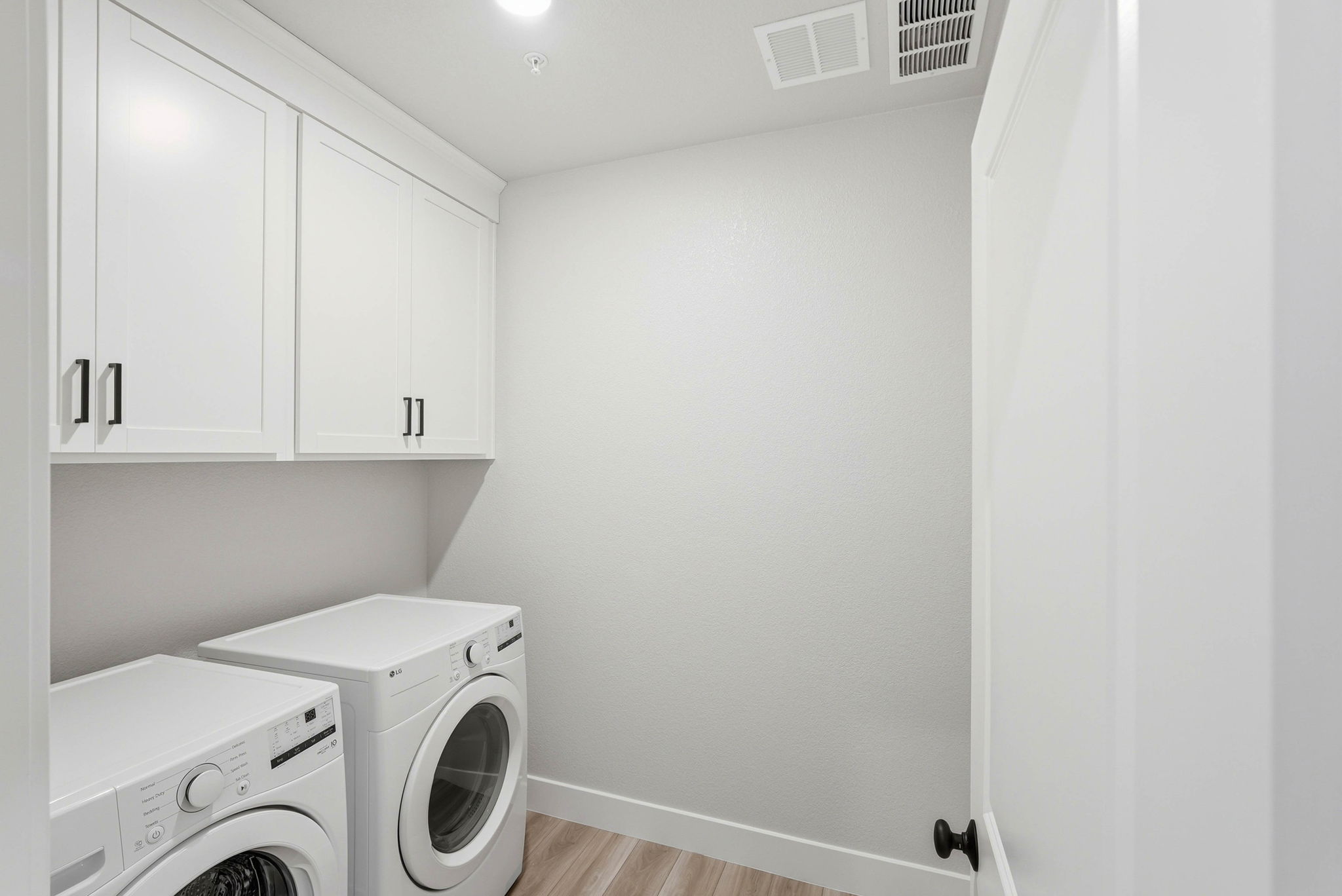 A white room with a washing machine and a dryer.