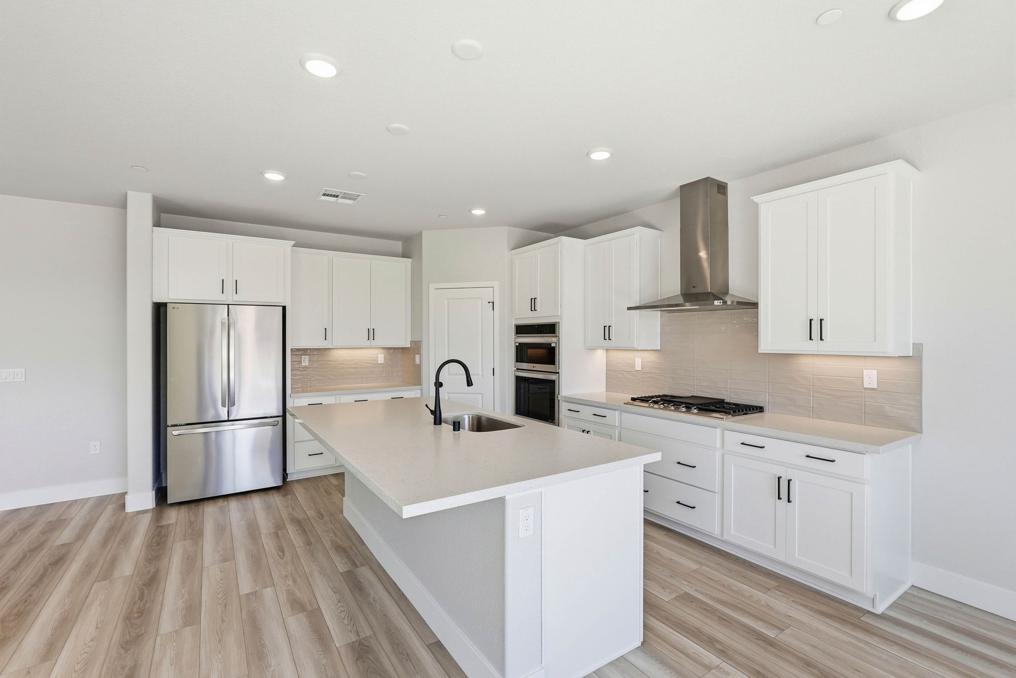 A kitchen with white cabinets.
