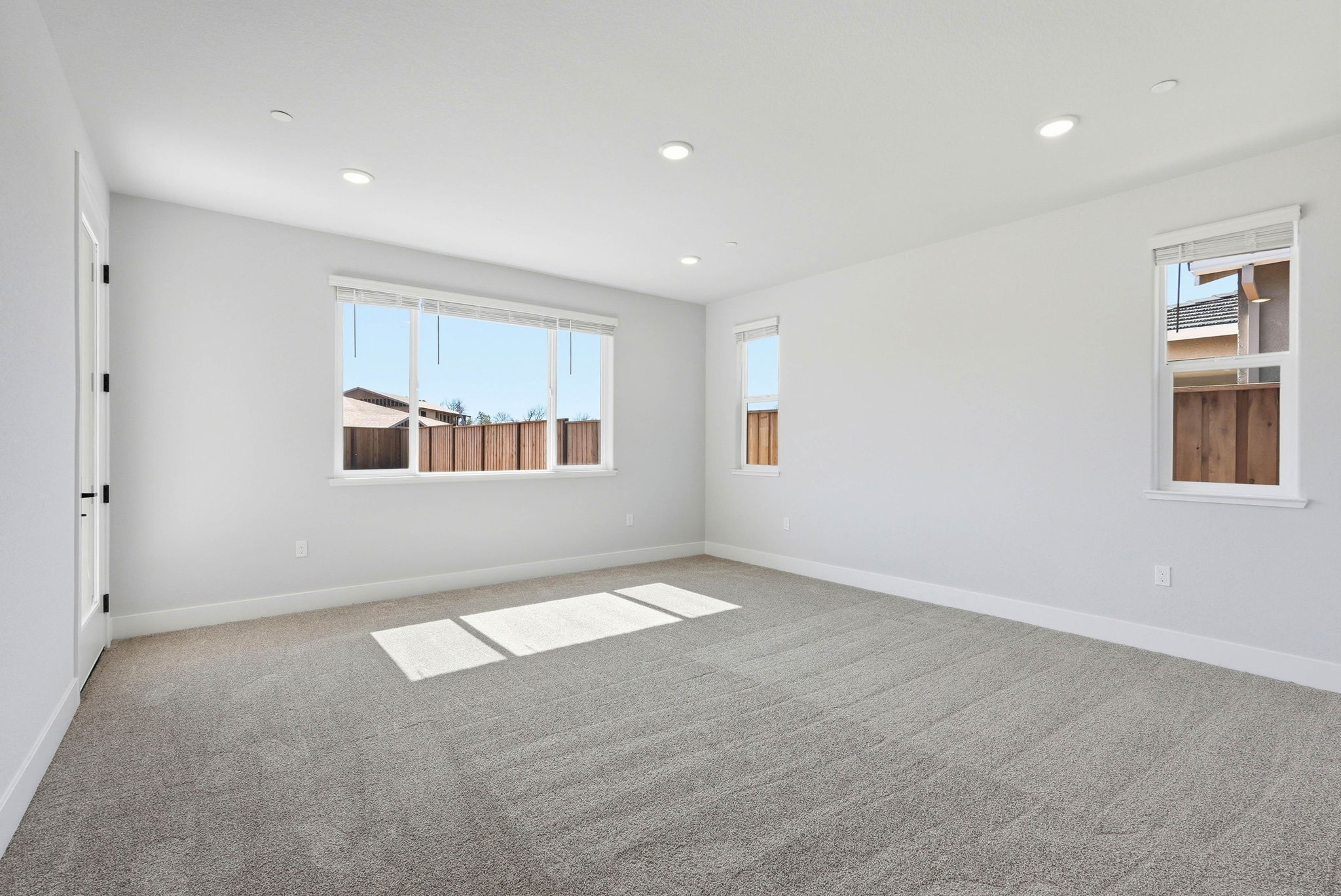 A room with a window and a rug.