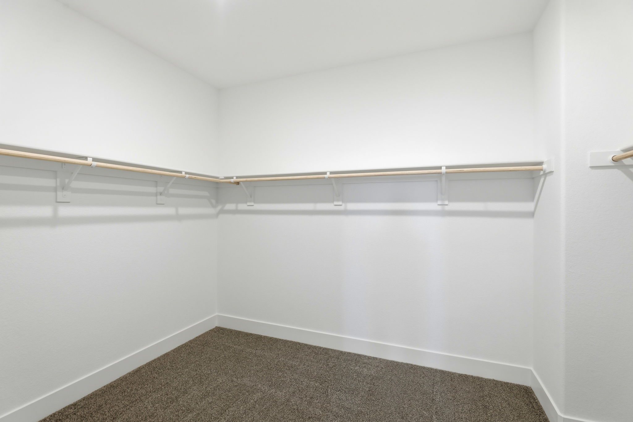 A white wall with a metal bar.