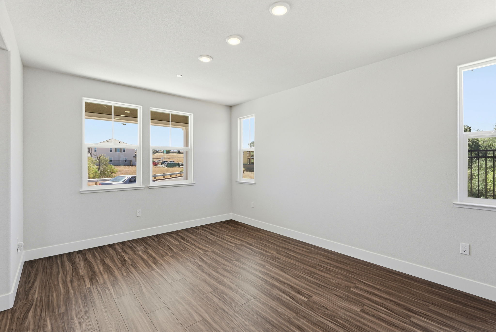 A room with a wood floor and windows.