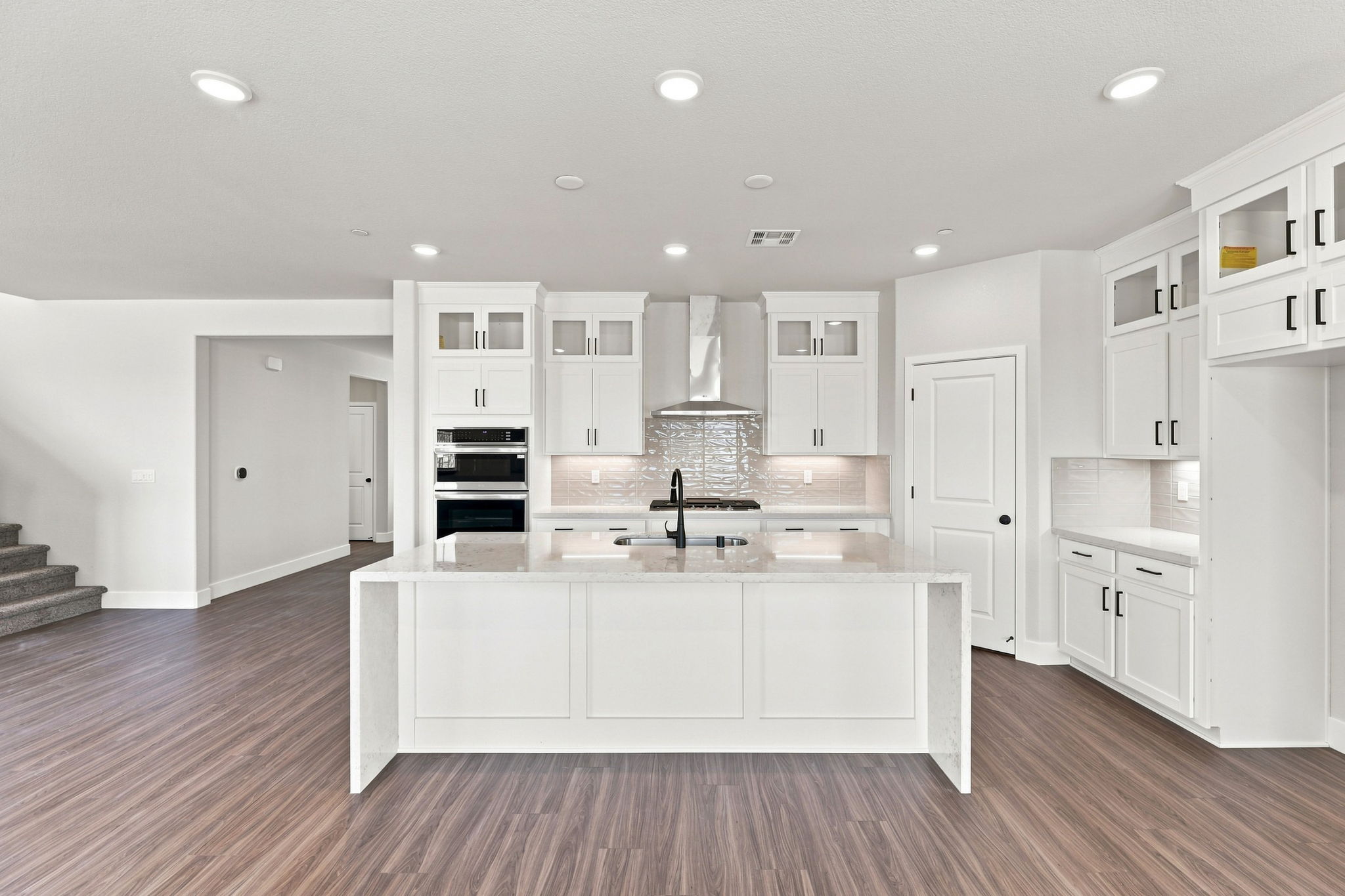 A kitchen with white cabinets.