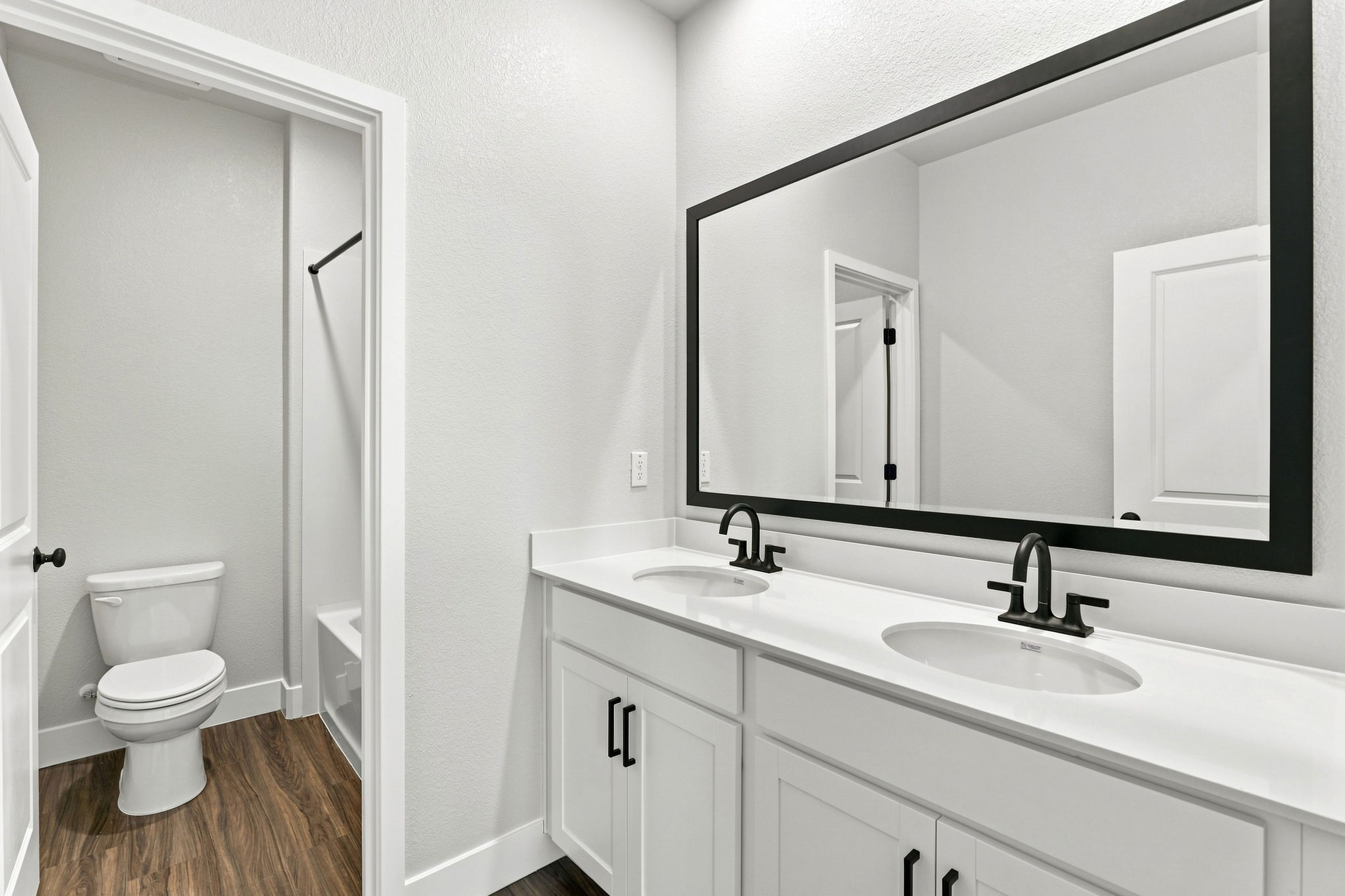 A bathroom with a sink toilet and mirror.
