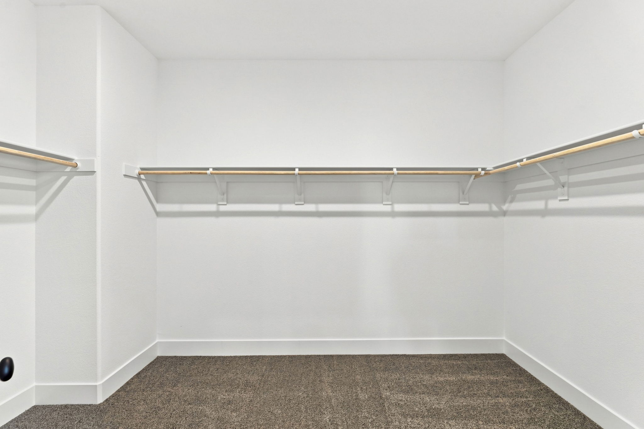 A white wall with a metal bar.