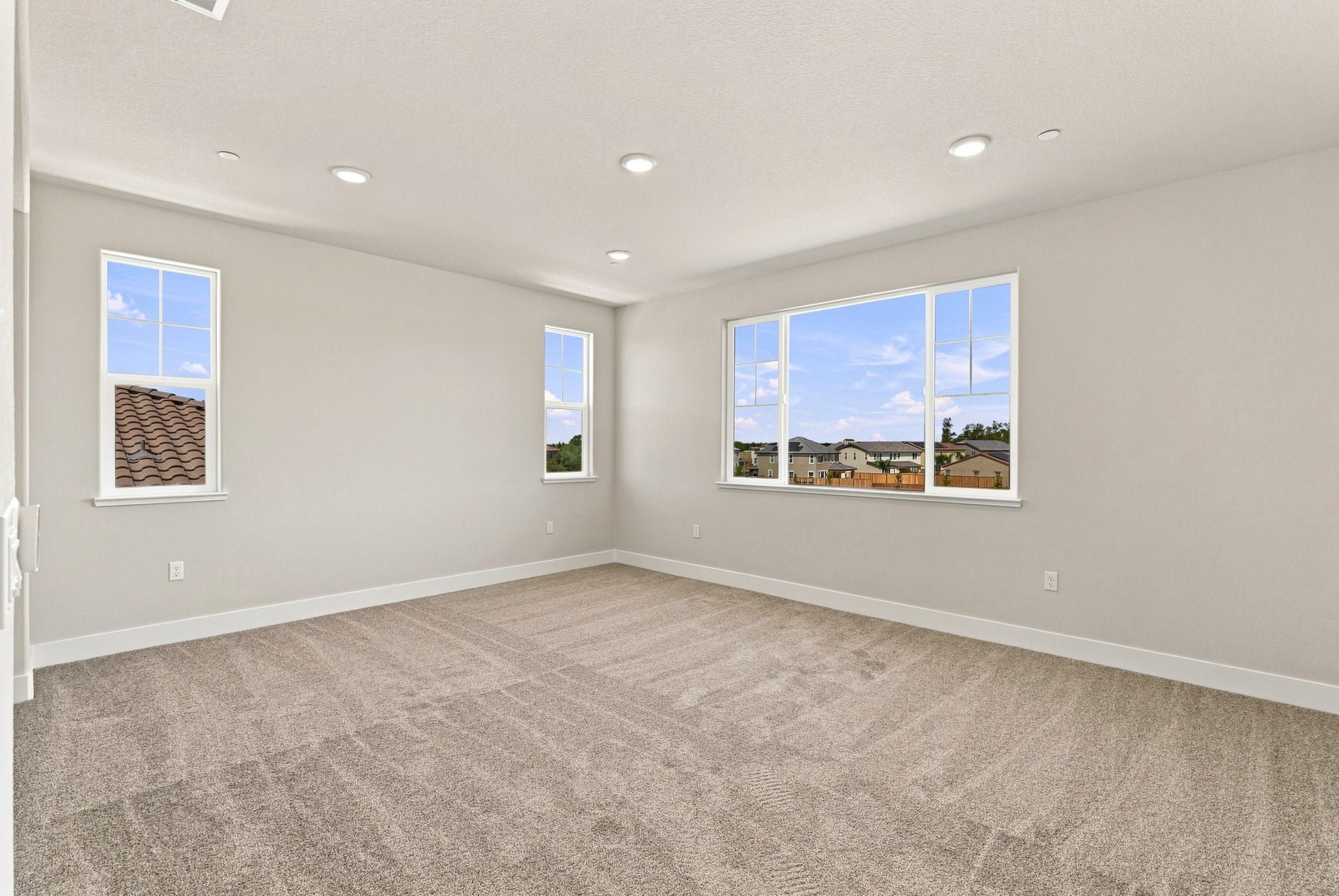 A room with a carpet and windows.