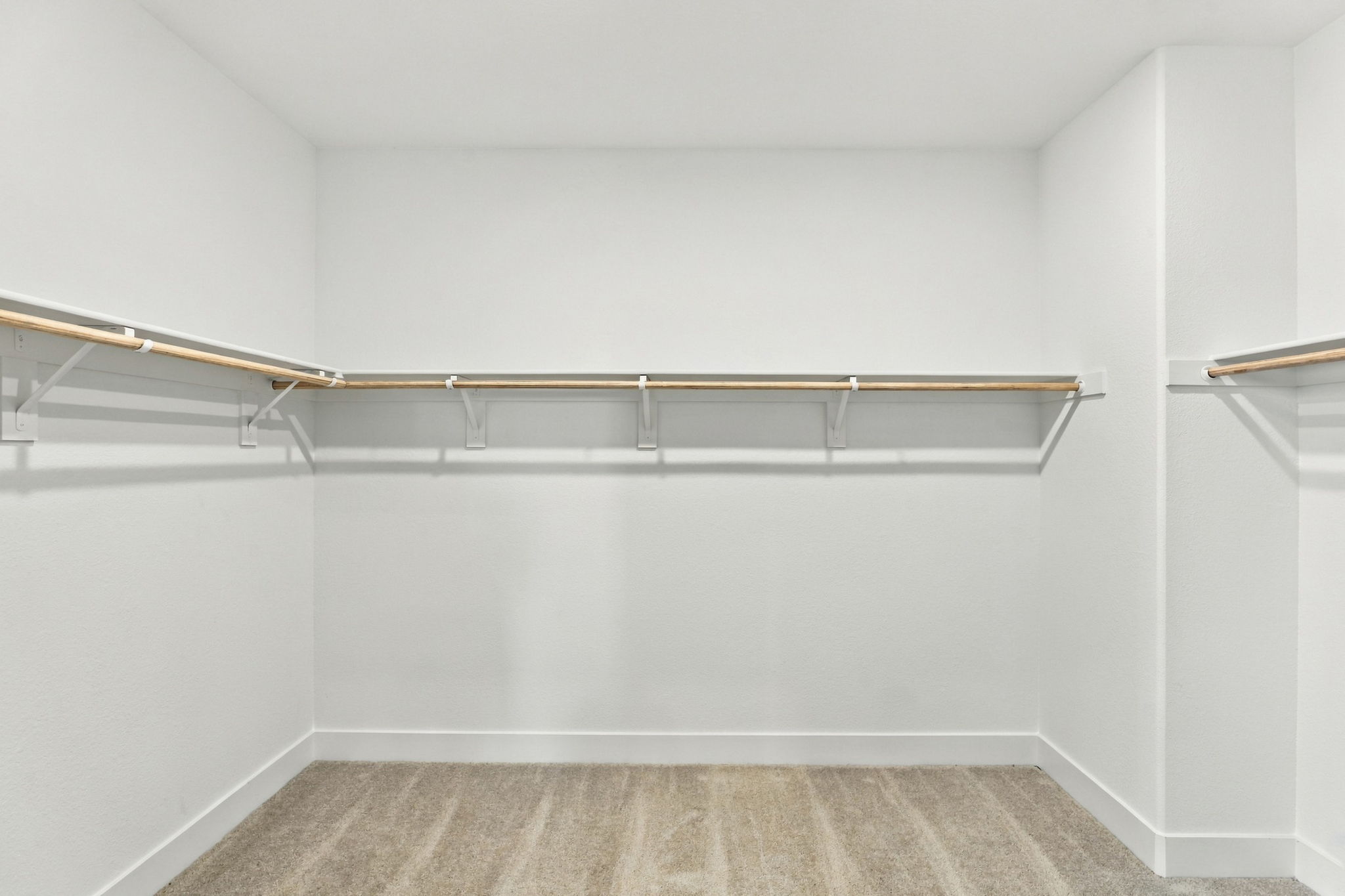 A white wall with a metal bar.