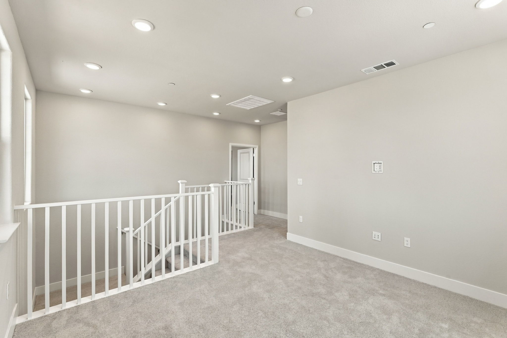 A white room with a white railing.