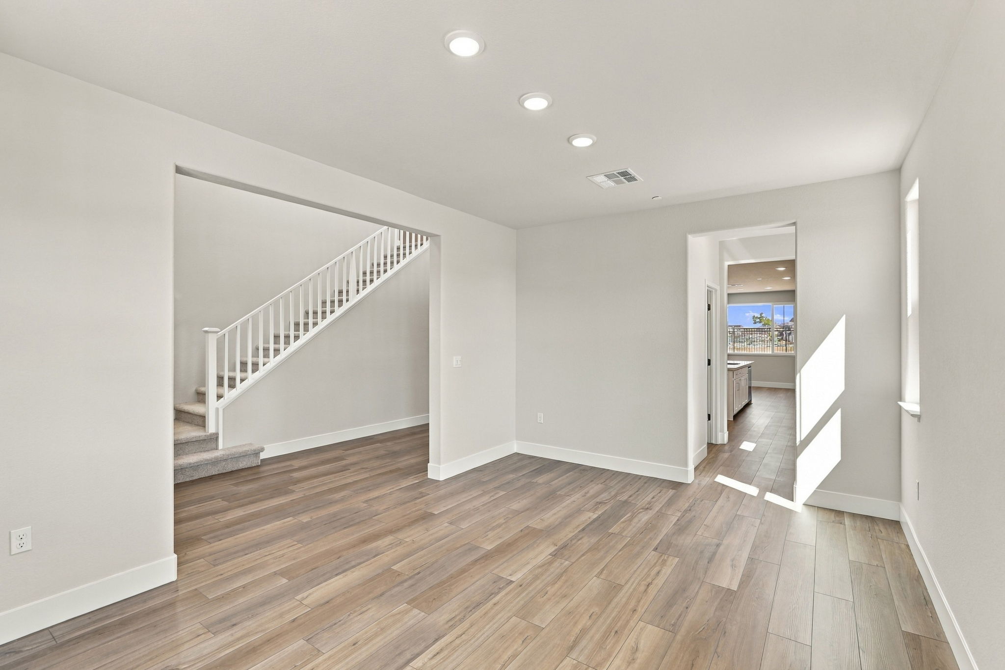 A room with a wood floor and white walls.