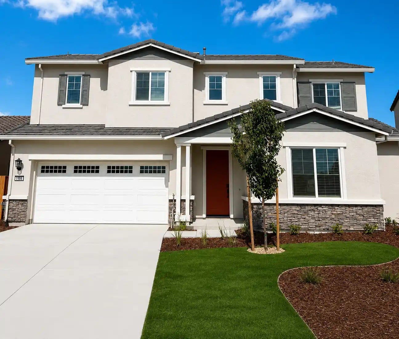 A house with a lawn and a tree in the front.