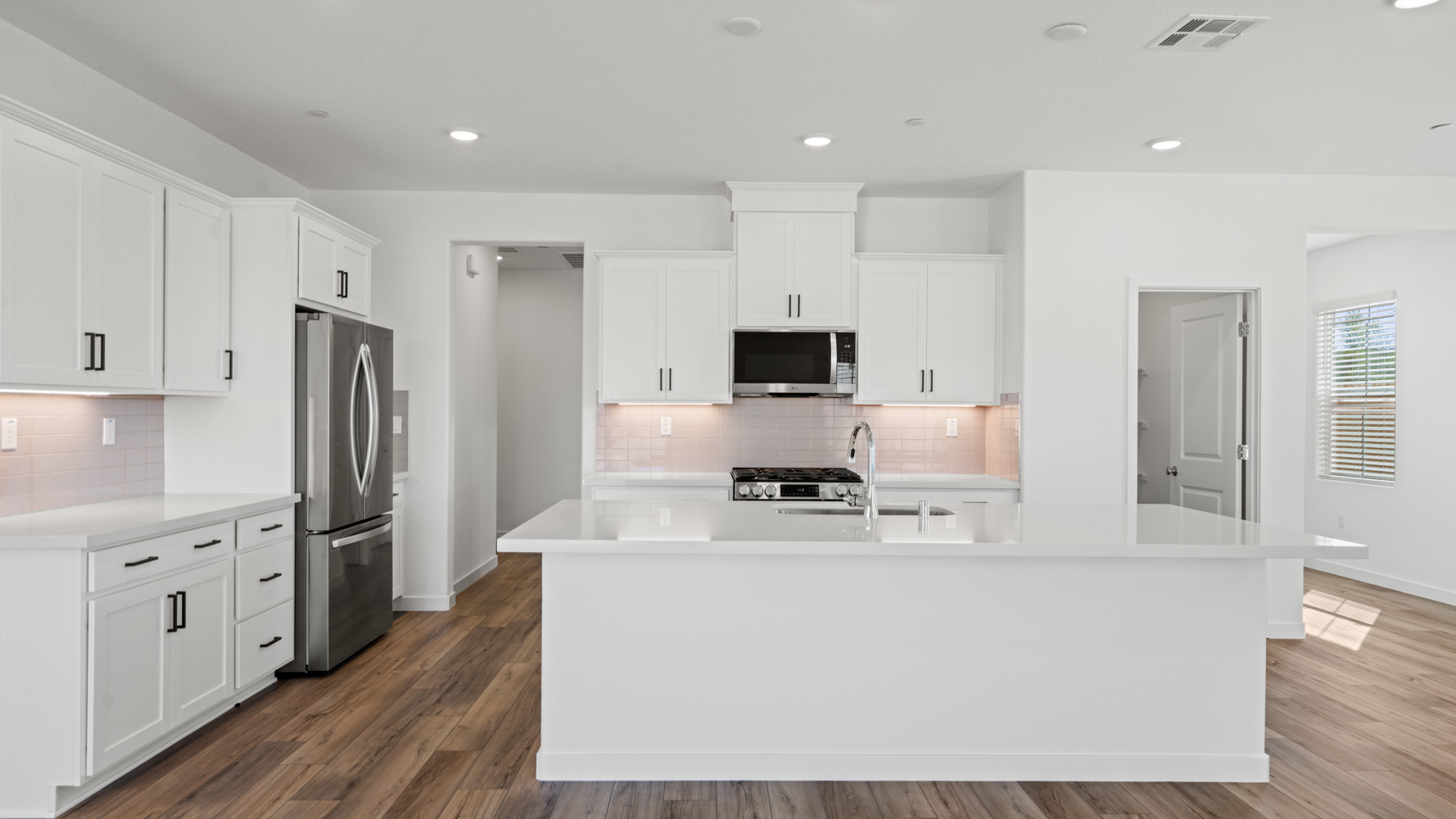A kitchen with white cabinets.