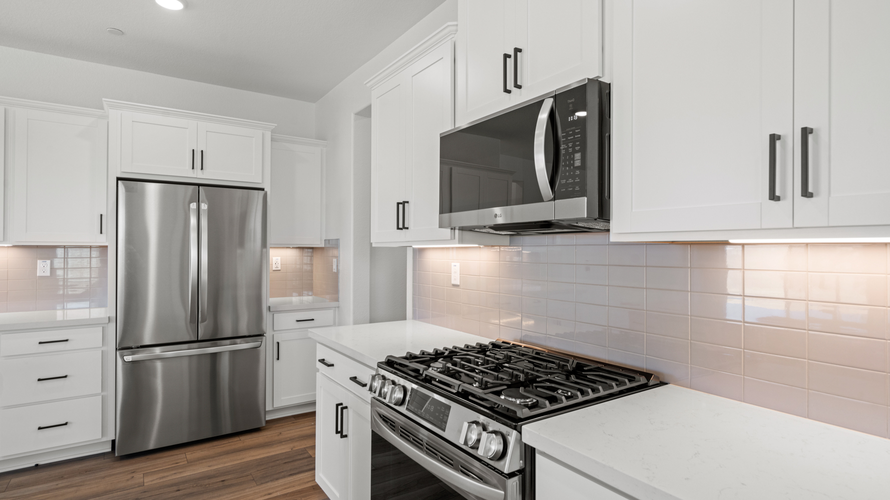 A kitchen with white cabinets.
