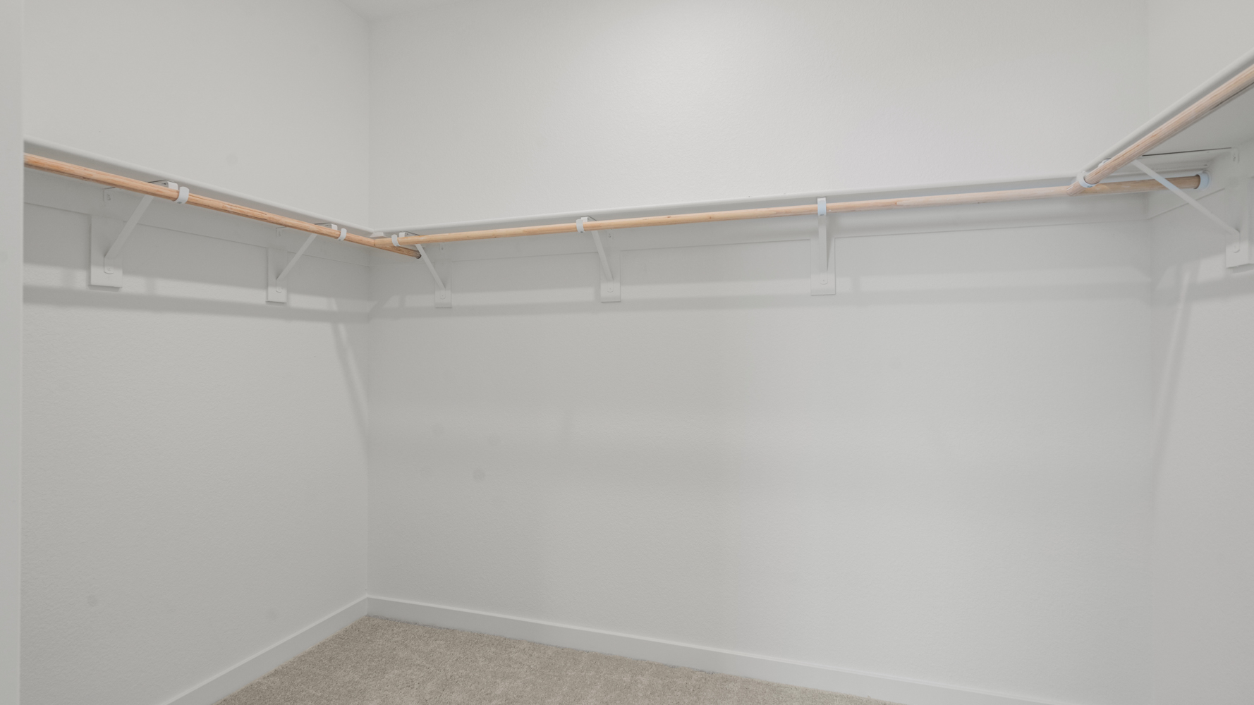 A white wall with a metal bar.