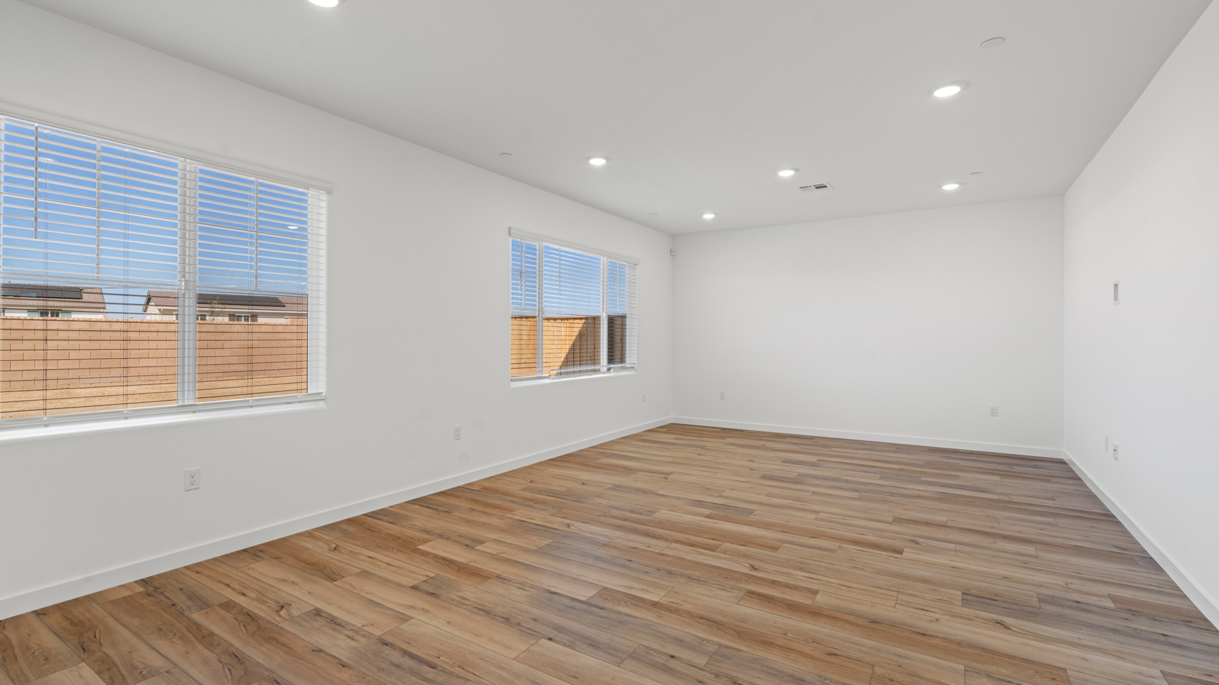 A room with a wood floor and windows.