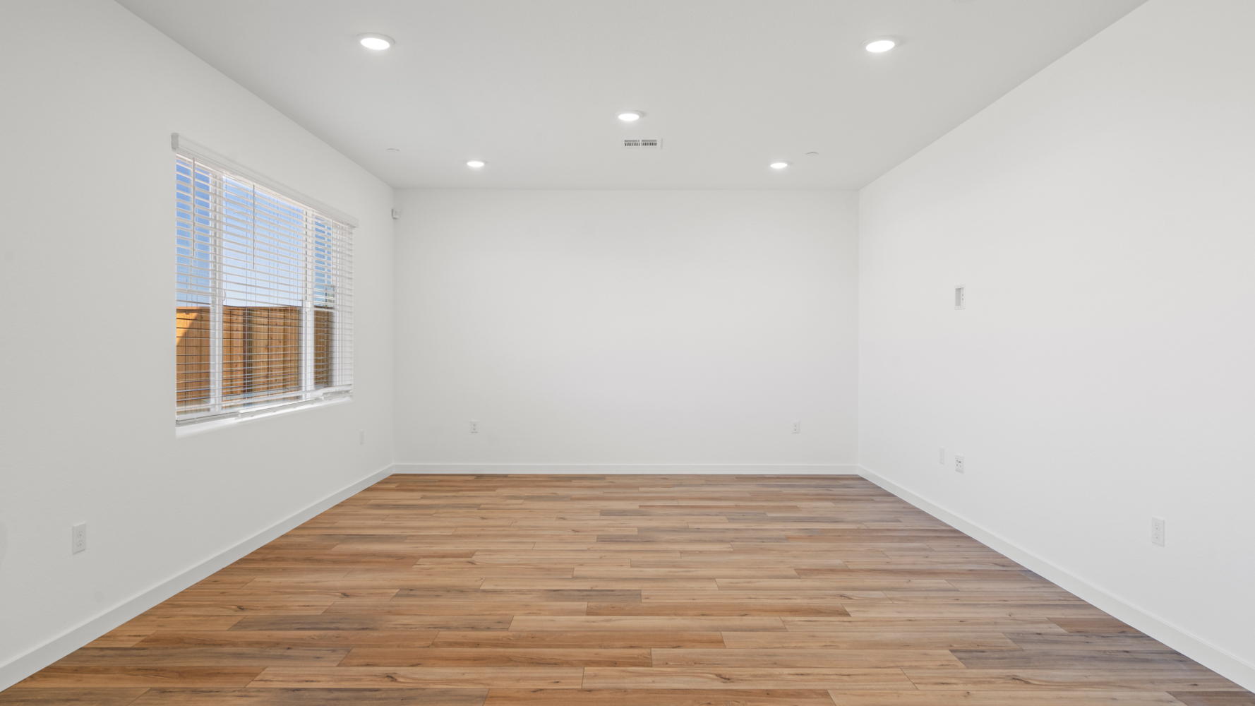 A room with a wood floor and a window.