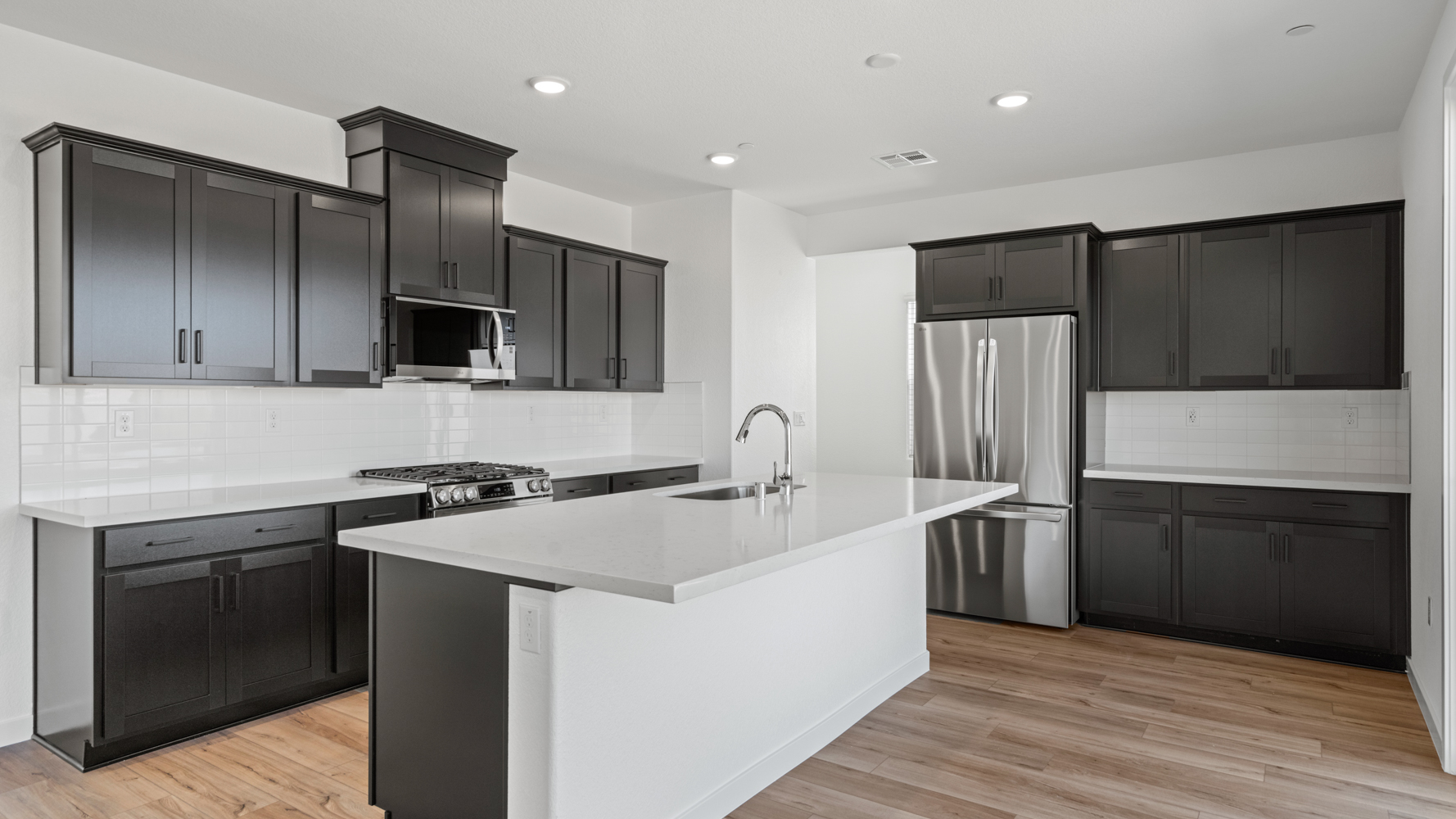 A kitchen with black cabinets.