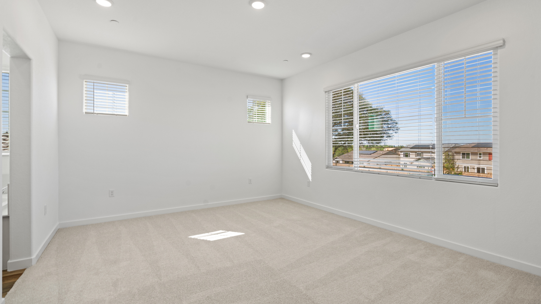 A room with a window and a white wall with a white floor.