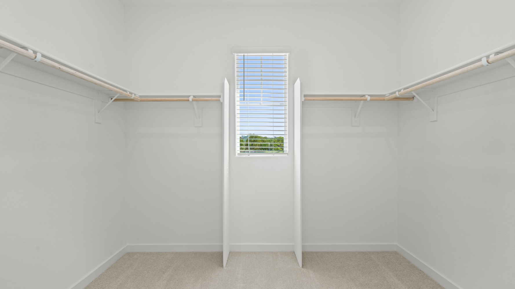 A room with a window and a white wall.