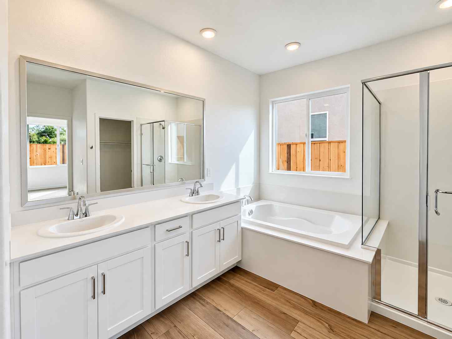 A bathroom with a tub sink and a mirror.
