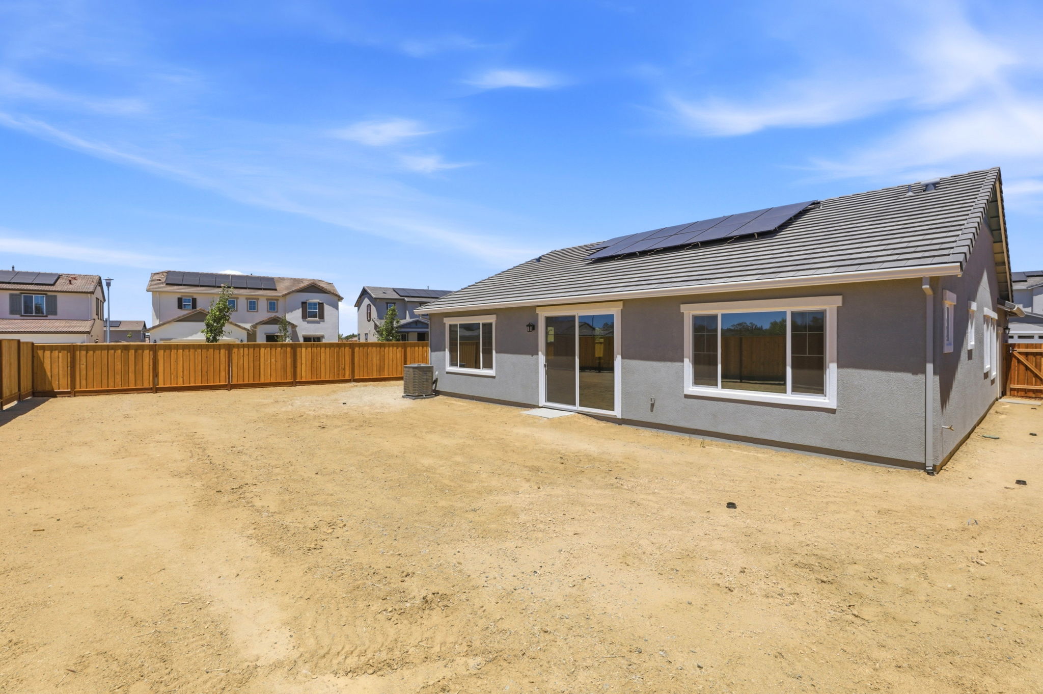 A house with a fence and dirt.