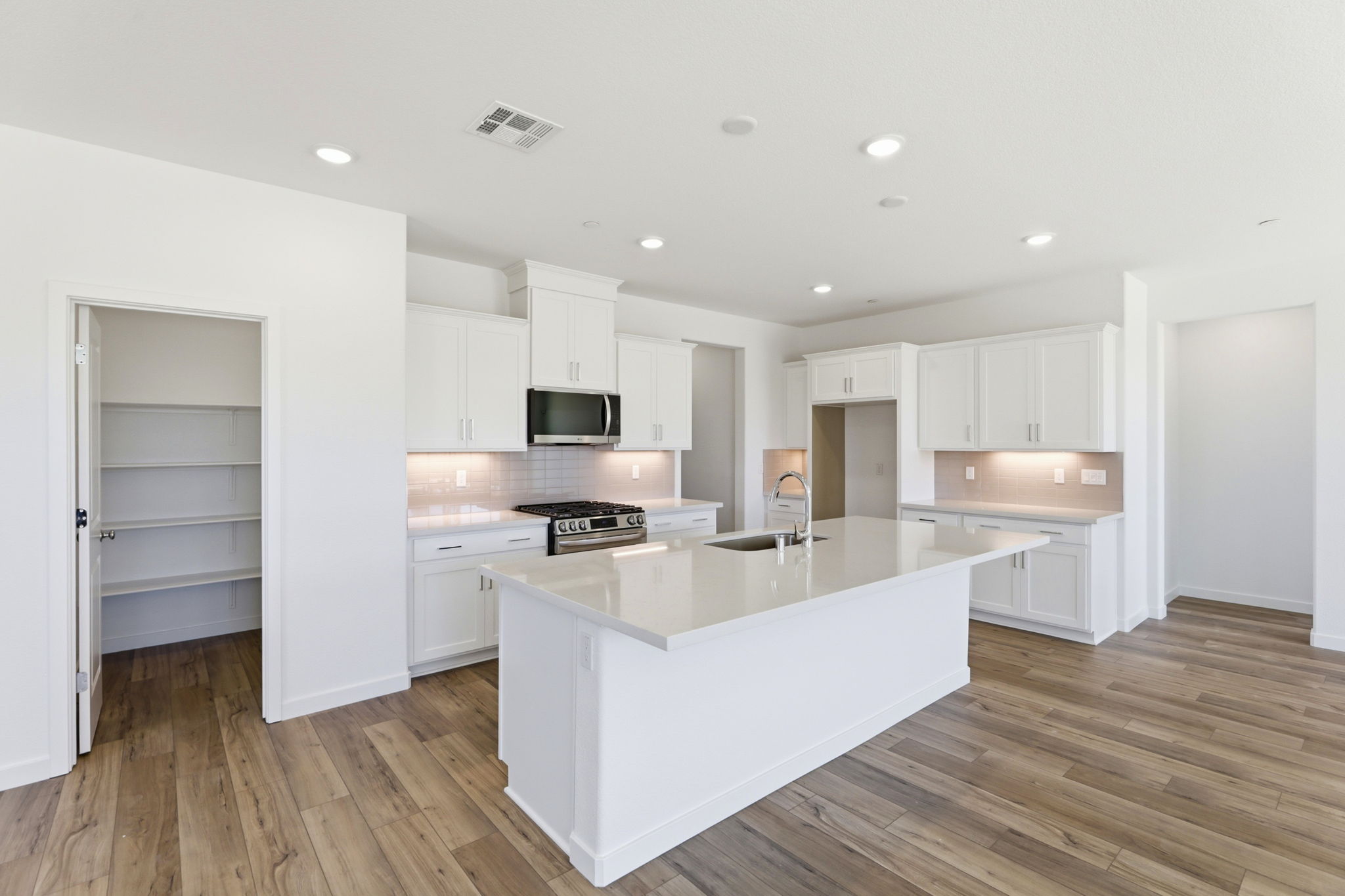 A kitchen with white cabinets.
