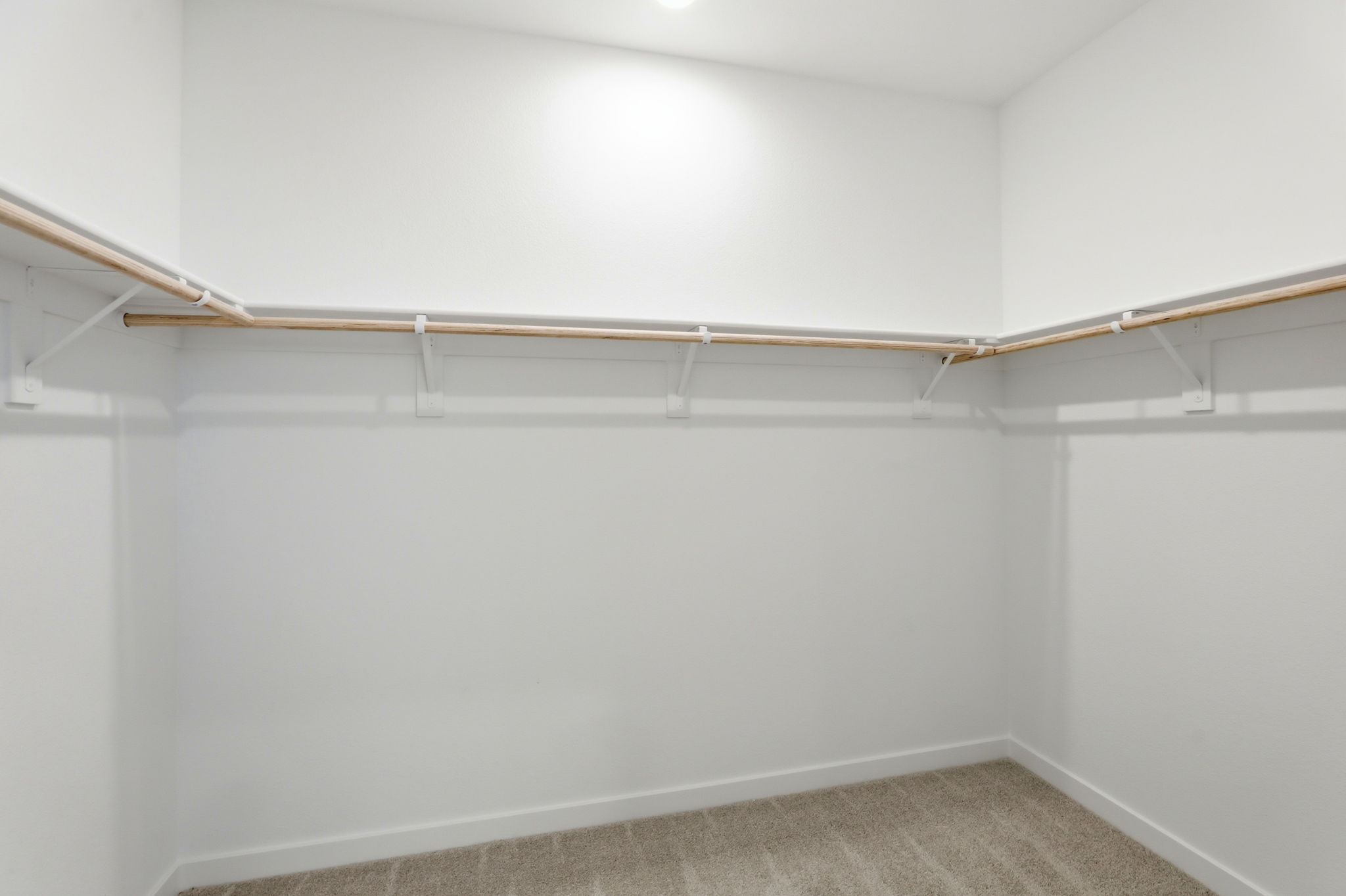 A white wall with a metal bar.