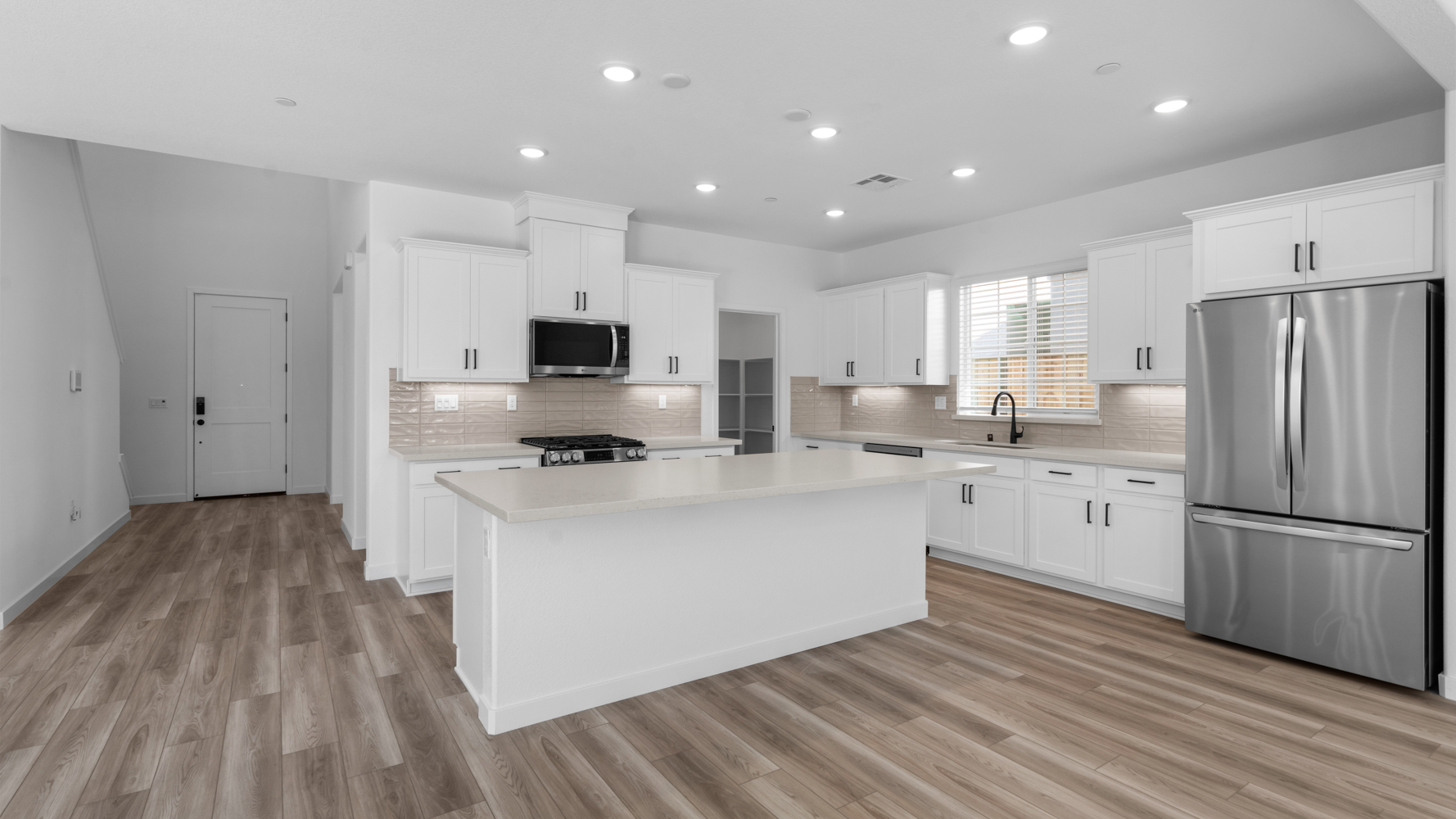 A kitchen with white cabinets.