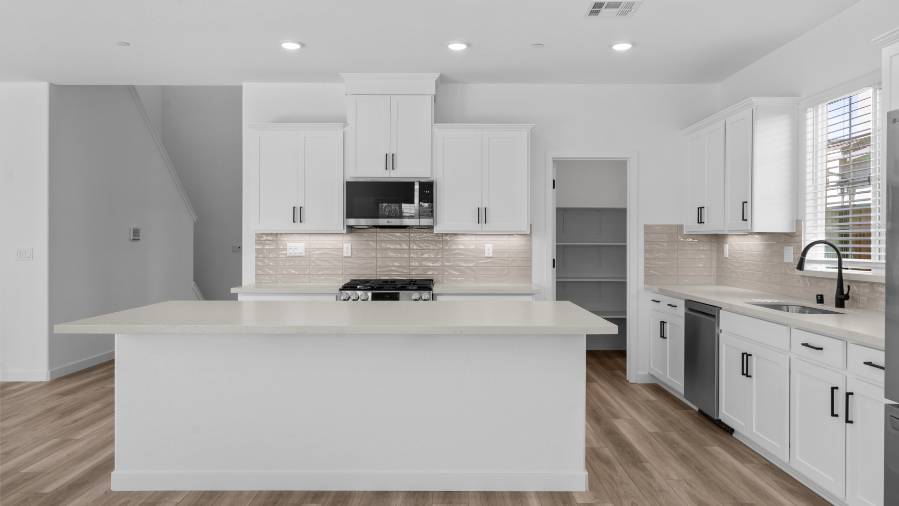 A kitchen with white cabinets.