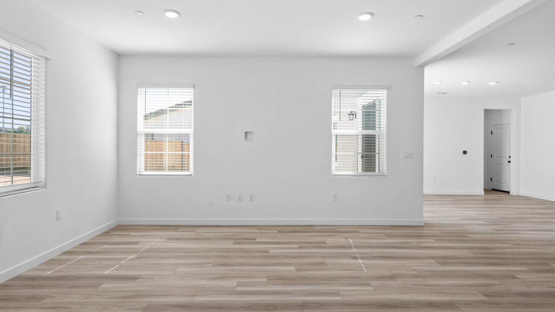 A room with a wood floor and windows.